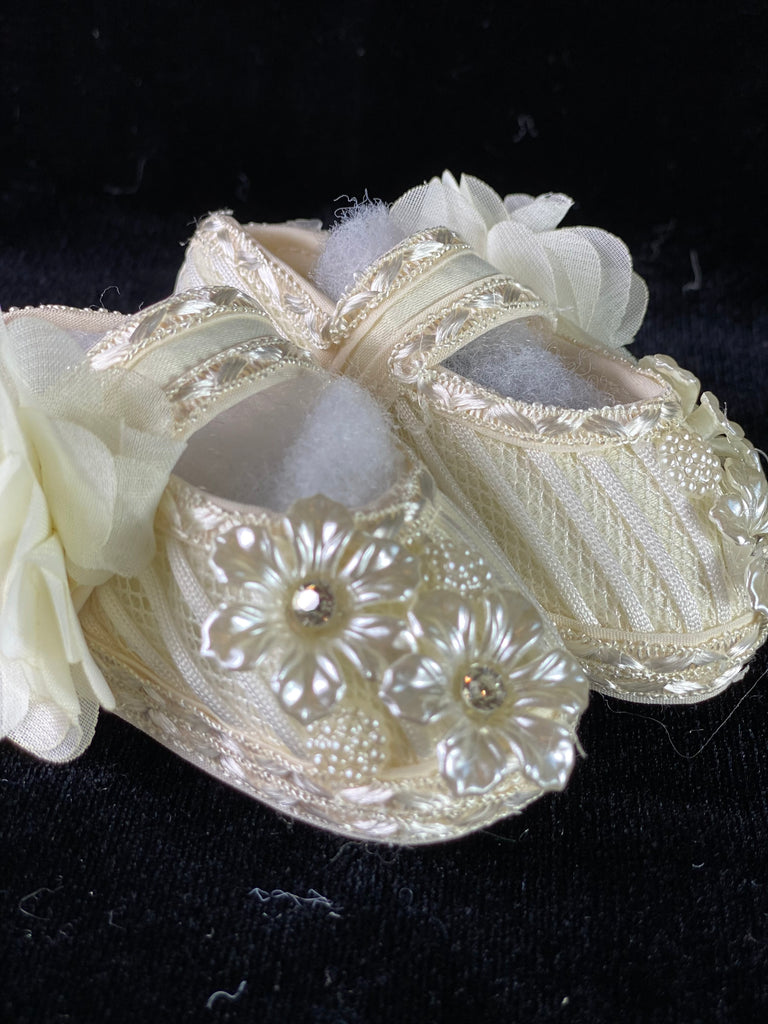 Elegant handmade ivory baby girl shoes with lace, flowers, and jewels.