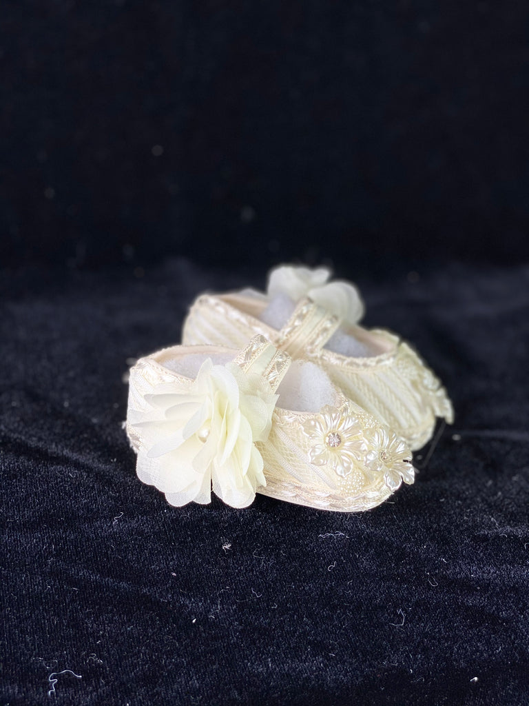 Elegant handmade ivory baby girl shoes with lace, flowers, and jewels.