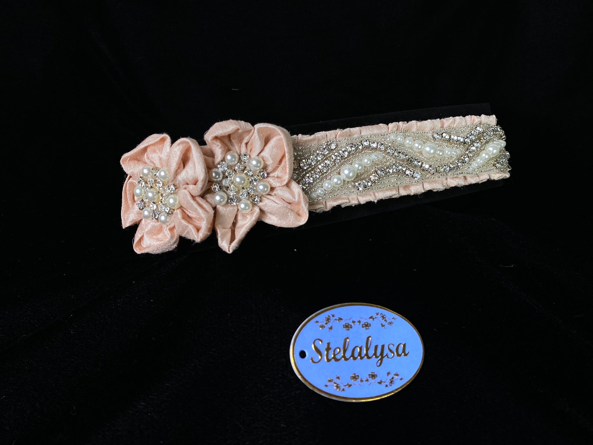 This is an elegant handmade and one-of-a-kind Pink (Dusty Rose) headwrap with a two large velvet flowers with rhinestones and pearls.  The elastic headwrap is made of a soft velvet with an intricate rhinestone and pearl design.  This headwrap can be worn with dresses from Stelalysa's Celebration/Pageant Collection and for any occasion!  It fits best on ages 1-6.