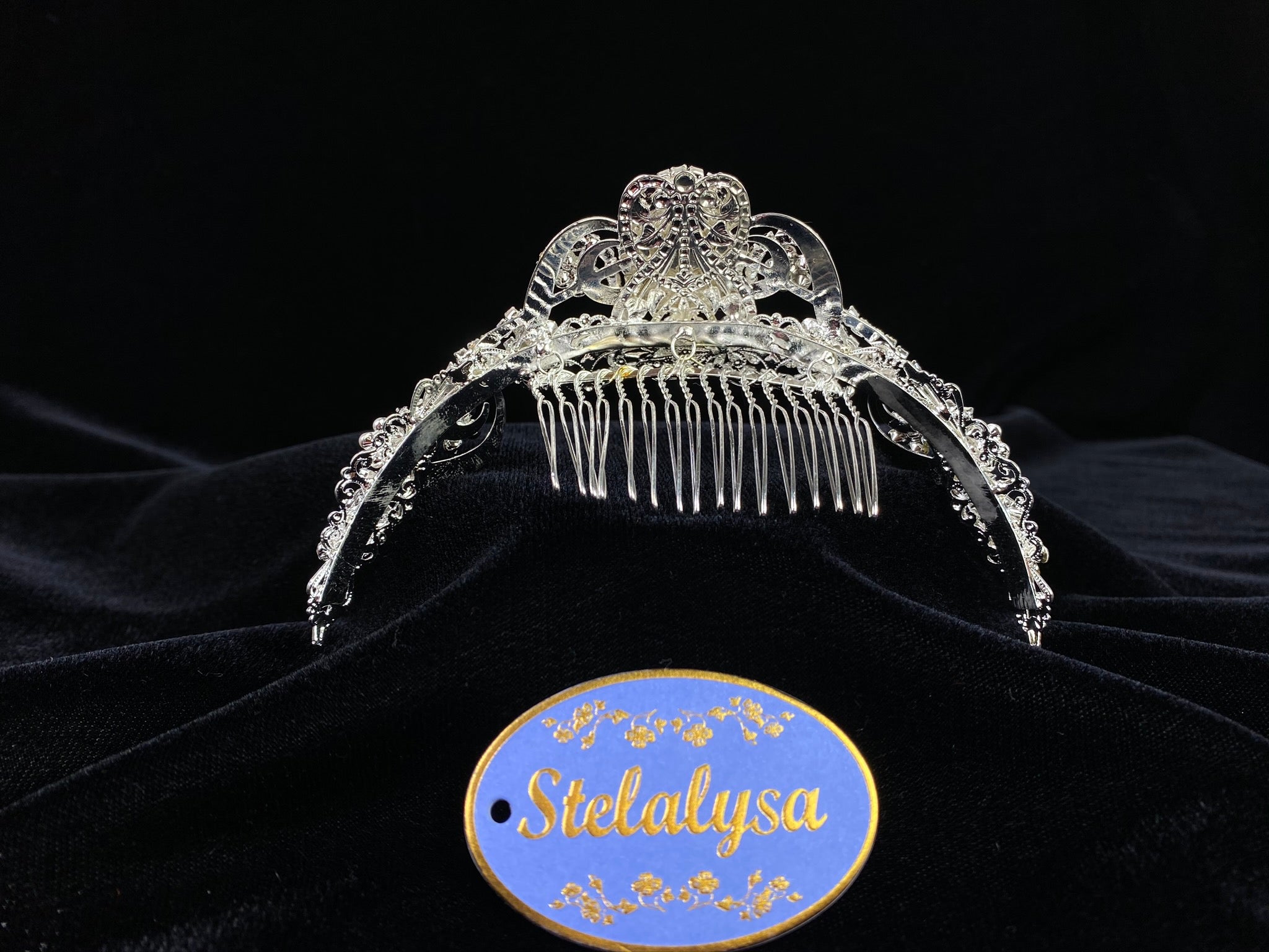 A must have for the First Communion!   Beautiful tiara, covered in gorgeous rhinestones. Pearl clusters create flowers around rhinestones.  Tiara is 5" across.  Wear this tiara with either a white or ivory veil from our Veil Collection to complete the look for the ceremony.