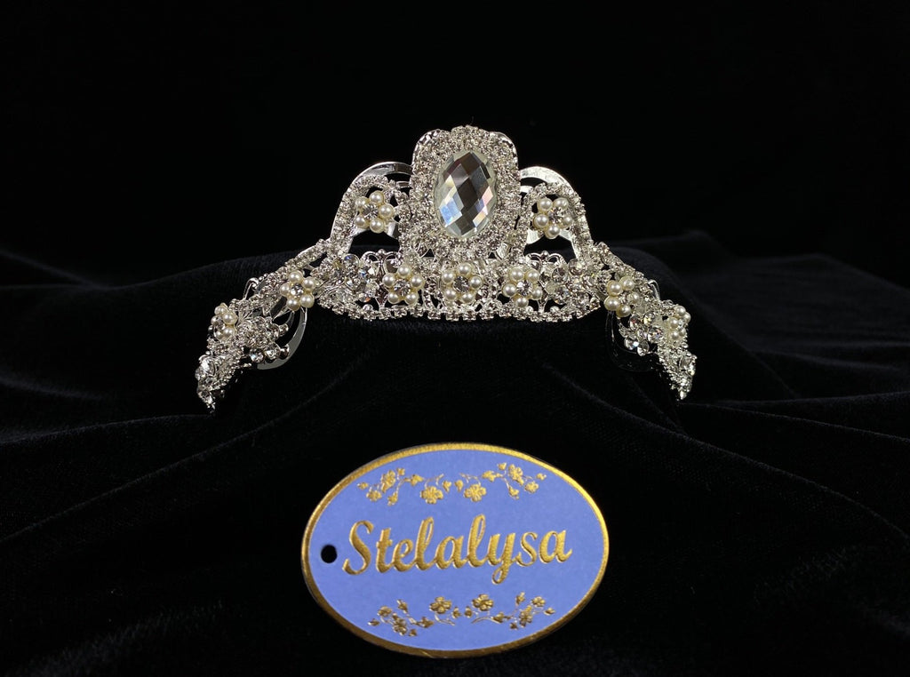 A must have for the First Communion!   Beautiful tiara, covered in gorgeous rhinestones. Pearl clusters create flowers around rhinestones.  Tiara is 5" across.  Wear this tiara with either a white or ivory veil from our Veil Collection to complete the look for the ceremony.