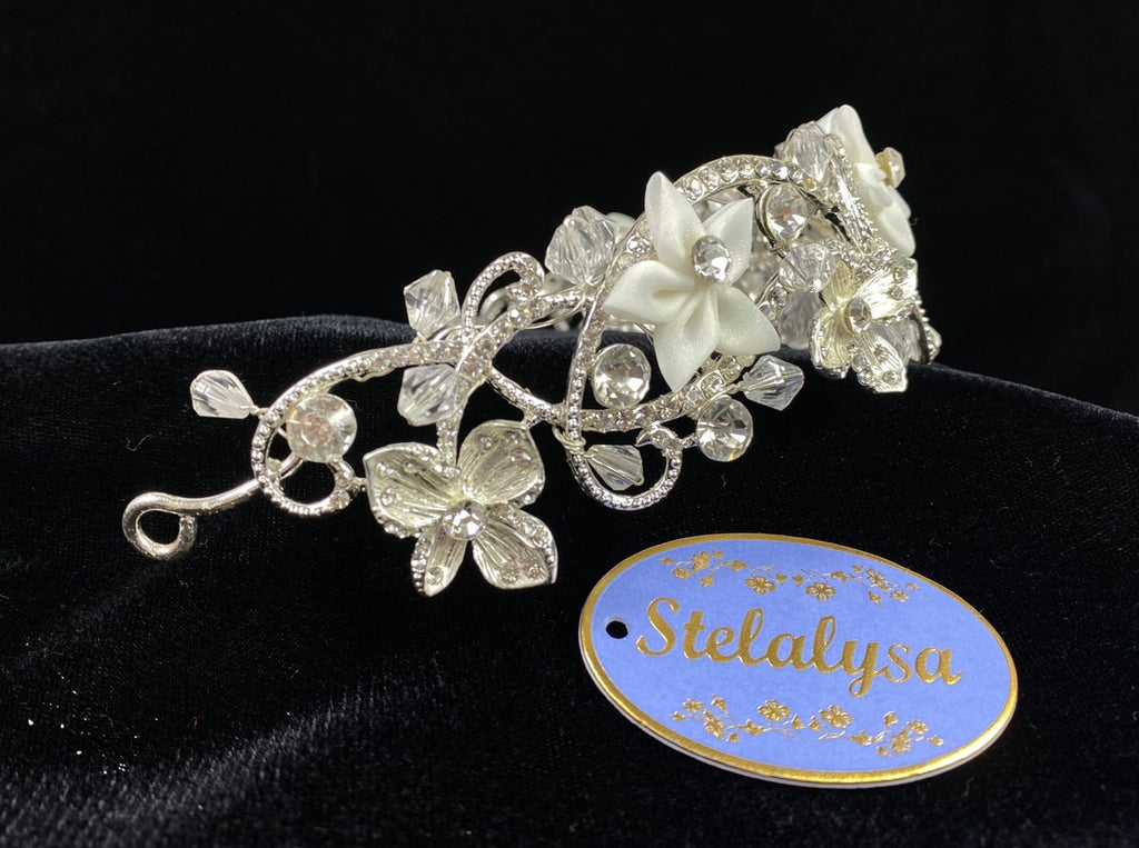 Gorgeous silver-tone metal rhinestone headband with white organza flowers.  Jewels placed along flower petals and centers.  Tiara goes about 2/3 of the way around the head.  Pin loops at the ends for added security.  Wear this tiara with one of our white veils to complete the look for the ceremony.