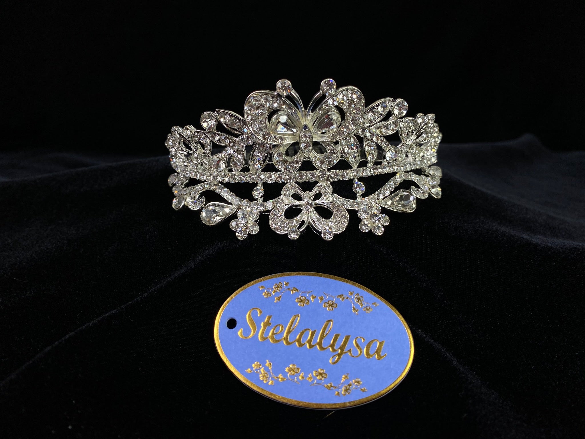 Beautiful tiara, covered in gorgeous rhinestones creating butterflies.  Tiara is 4" wide with a 3" comb.  Wear this tiara with either a white or ivory veil from our Veil Collection to complete the look for the ceremony.