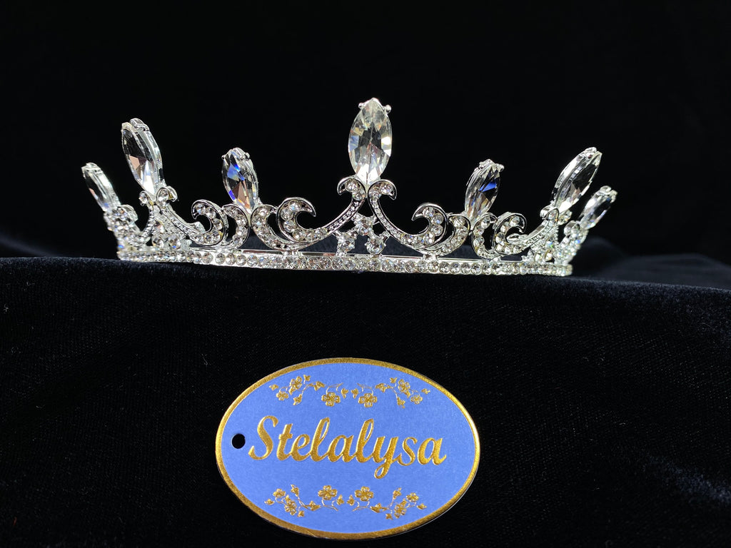 A must have for the First Communion!   Beautiful traditional rhinestone tiara with large rhinestones in each high tip.  This elegant tiara comes with 2 combs on each end to secure it in place.    Tiara goes about 2/3 of the way around the head.  Pin loops at the ends for added security.  Wear this tiara with either a white or ivory veil from our Veil Collection to complete the look for the ceremony.