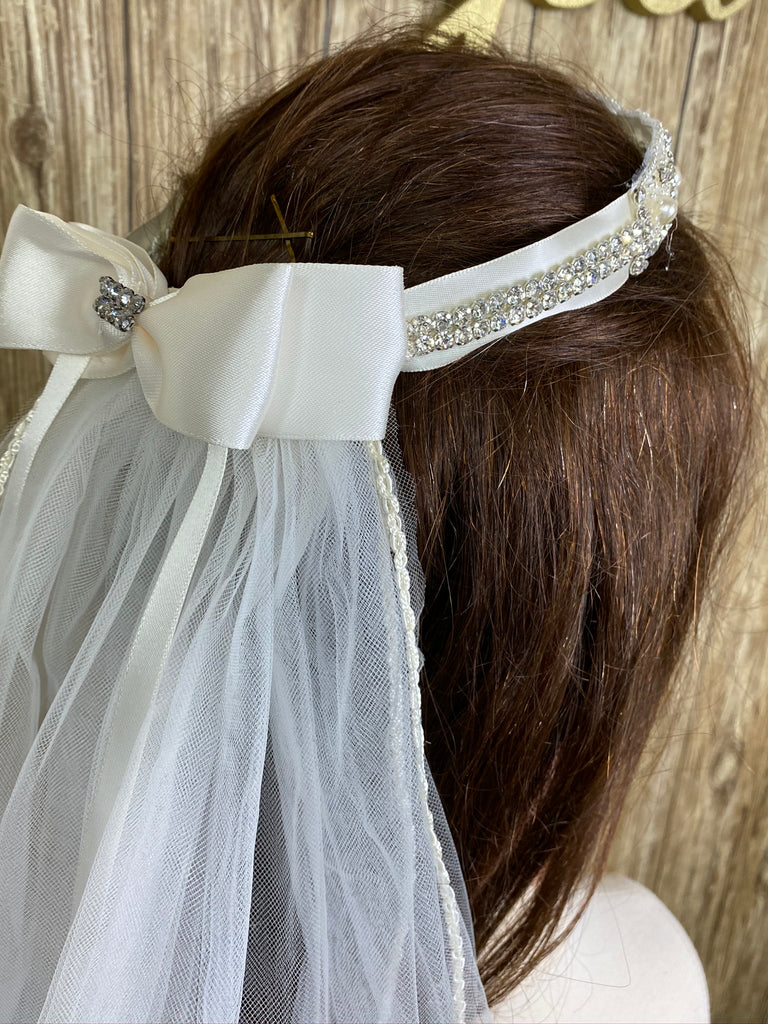 Ivory Crown Veil  Elegant soft 2 layer tulle veil with delicate hand stitched braided satin trim around the edge.  Handmade halo crown veil with large ivory satin bow on back. Intricate pearl and rhinestone detailing around band of crown. Braided satin trim around veil edge.   This double layered veil reaches approximately 24" long, with a crown diameter of 6". Veil has 2" long, 3" wide, comb to secure it in place.   Materials:  sturdy plastic comb, crown with pearls and rhinestones and soft tulle.