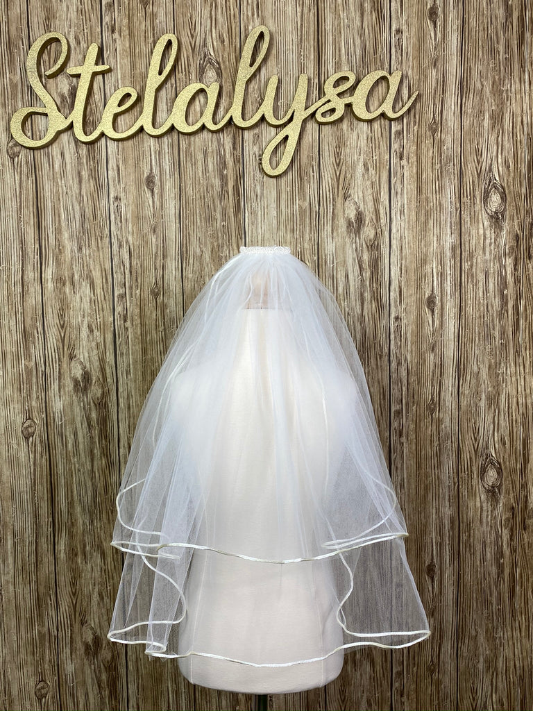 Ivory - Classic Veil for First Communion   Elegant soft 2 layer tulle veil with delicate hand stitched braided satin trim around the edge.  Veil length - 22 in. long  Handmade halo ivory lace crown with comb (2 in. wide to secure in place).  Materials:  sturdy plastic comb and soft tulle.