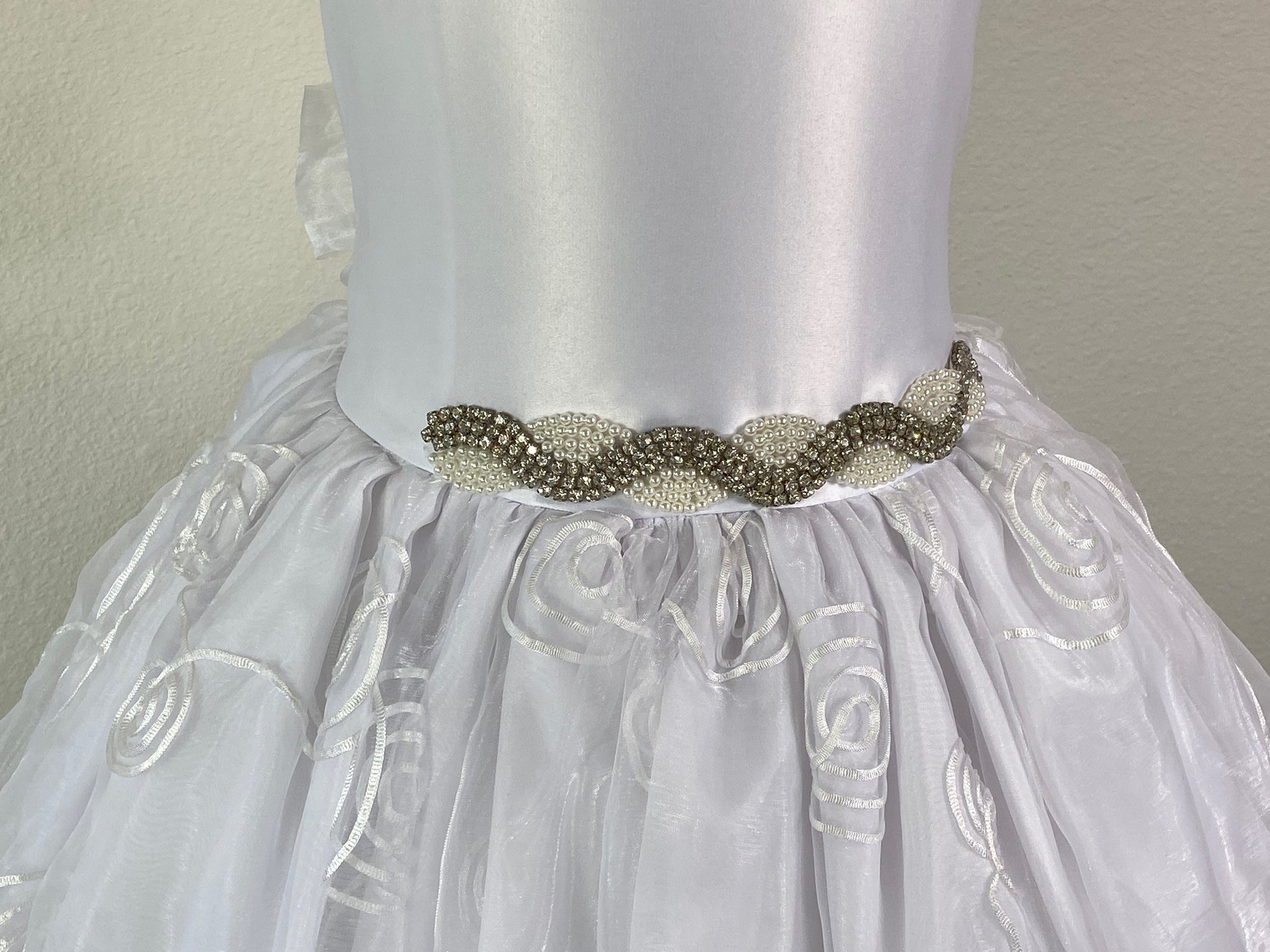 White, size 8 Satin bodice Scoop Neckline Pearl and Diamond Twisted Belt Detailing Four Layered Tulle over Satin Dress with swirl design Button closure in back Mesh ribbon for bow