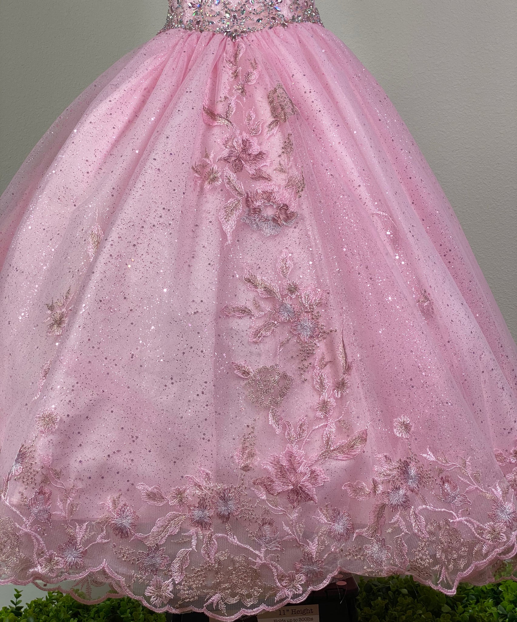 Pink, size 6 Pink circle neckline with paneled bodice Bedazzled appliques over entire bodice and neckline Pink glittered tulle over satin skirting Embroidered flowers over tulle on skirting Corset backing Dress pictured with a petticoat Petticoat not included  Choose from a tulle, cloth, or wire for best look