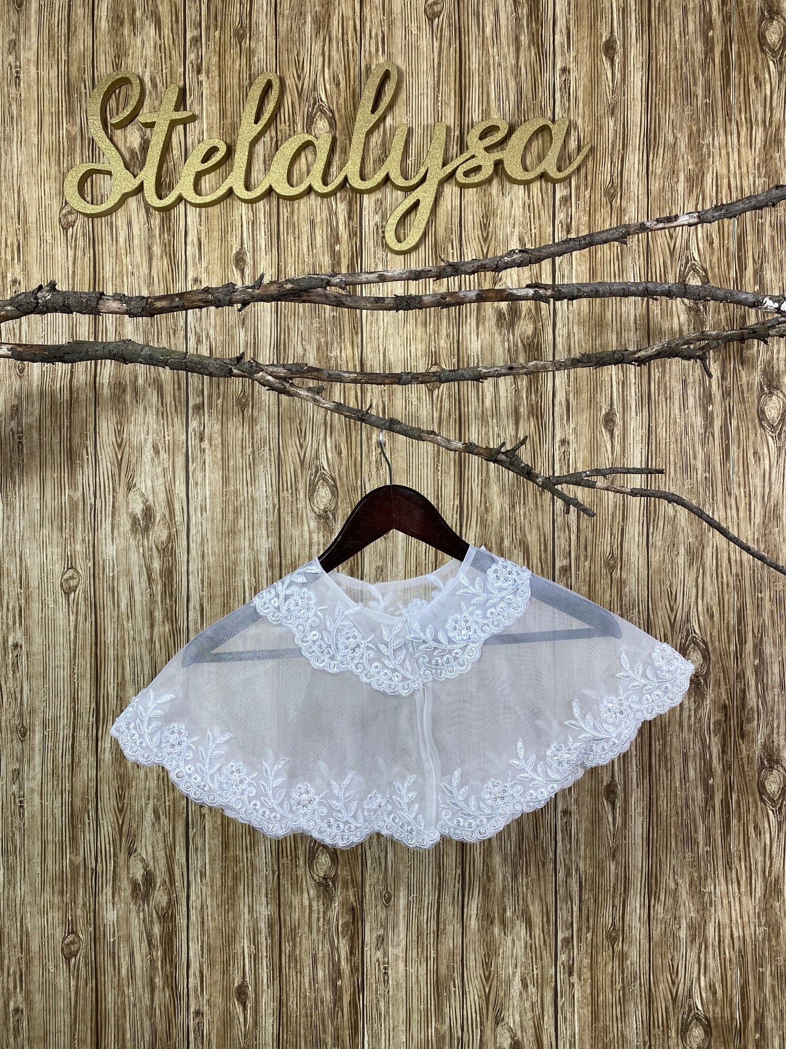 Beautiful tulle shawl with embroidered lace, along a scalloped edge.  This shawl can be worn with either a white or ivory communion dress/gown from our collection.  She will look like a princess wearing this elegant shawl on her special day!