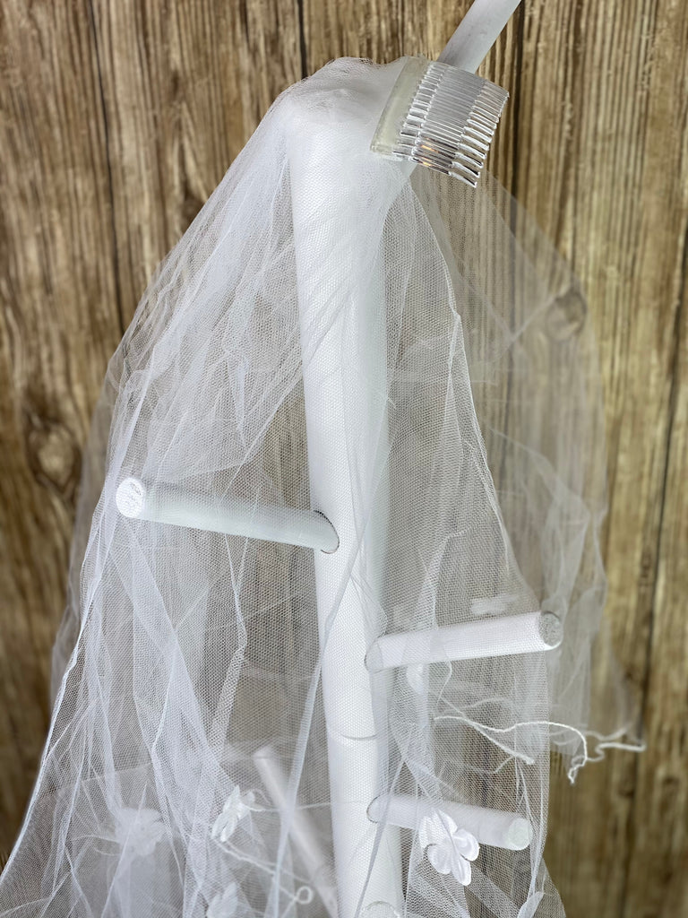 White - Flower Veil for First Communion   Elegant soft 2 layer tulle veil with delicate hand stitched white pencil trim and floating flowers.  Veil length - 35 in. long, comb - 7 cm wide  Materials:  sturdy plastic comb, soft tulle, and applique - flowers.