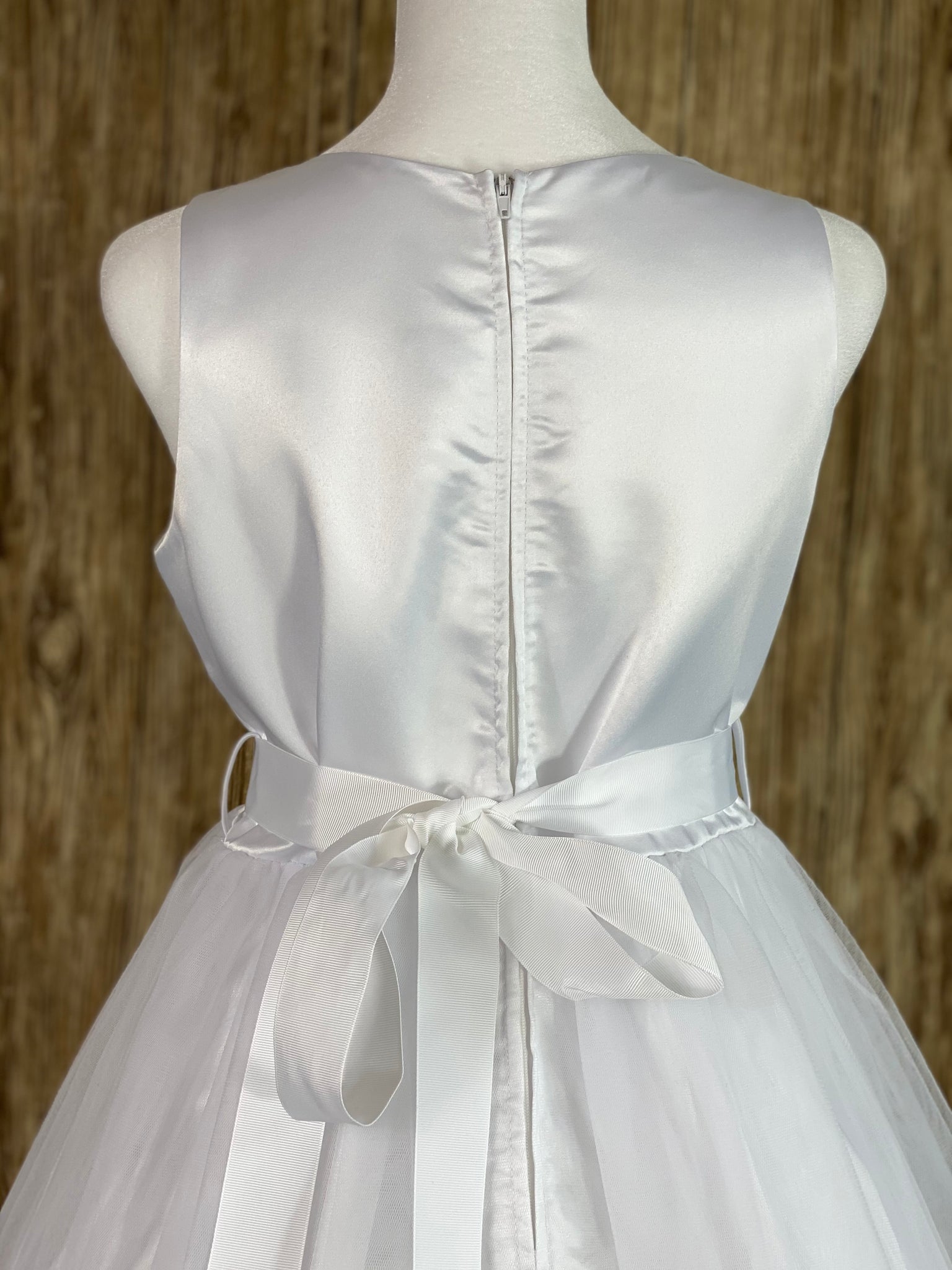 Paneled satin bodice Tulle skirt with lace edge Ribbon rhinestone and pearl with satin leaves belt Zipper closure Ribbon bow in back