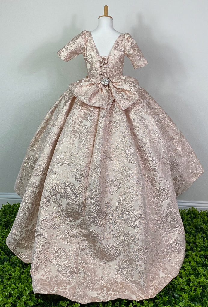 Embossed Champagne or Rose Gold bodice Quarter sleeve Champagne or Rose Gold embroidered applique over bodice Thin rhinestone band around lower bodice Two flowers with rhinestone centers on lower bodice and skirt Pleated embossed skirting Corset back Large bow with rhinestone center on back Dress pictured with a petticoat Petticoat not included  Choose from a tulle, cloth, or wire for best look See Stelalysa's Headbands / Accessories for a matching headband