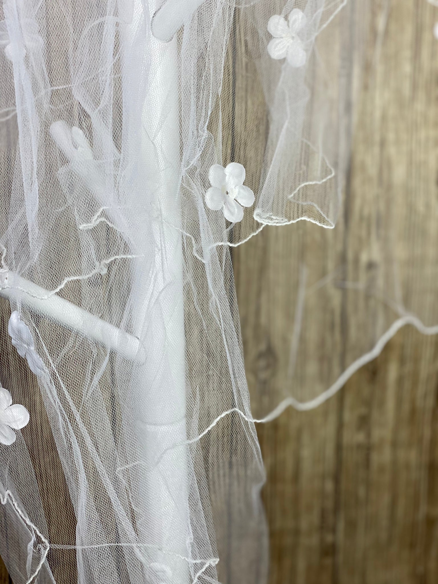 White - Flower Veil for First Communion   Elegant soft 2 layer tulle veil with delicate hand stitched white pencil trim and floating flowers.  Veil length - 35 in. long, comb - 7 cm wide  Materials:  sturdy plastic comb, soft tulle, and applique - flowers.