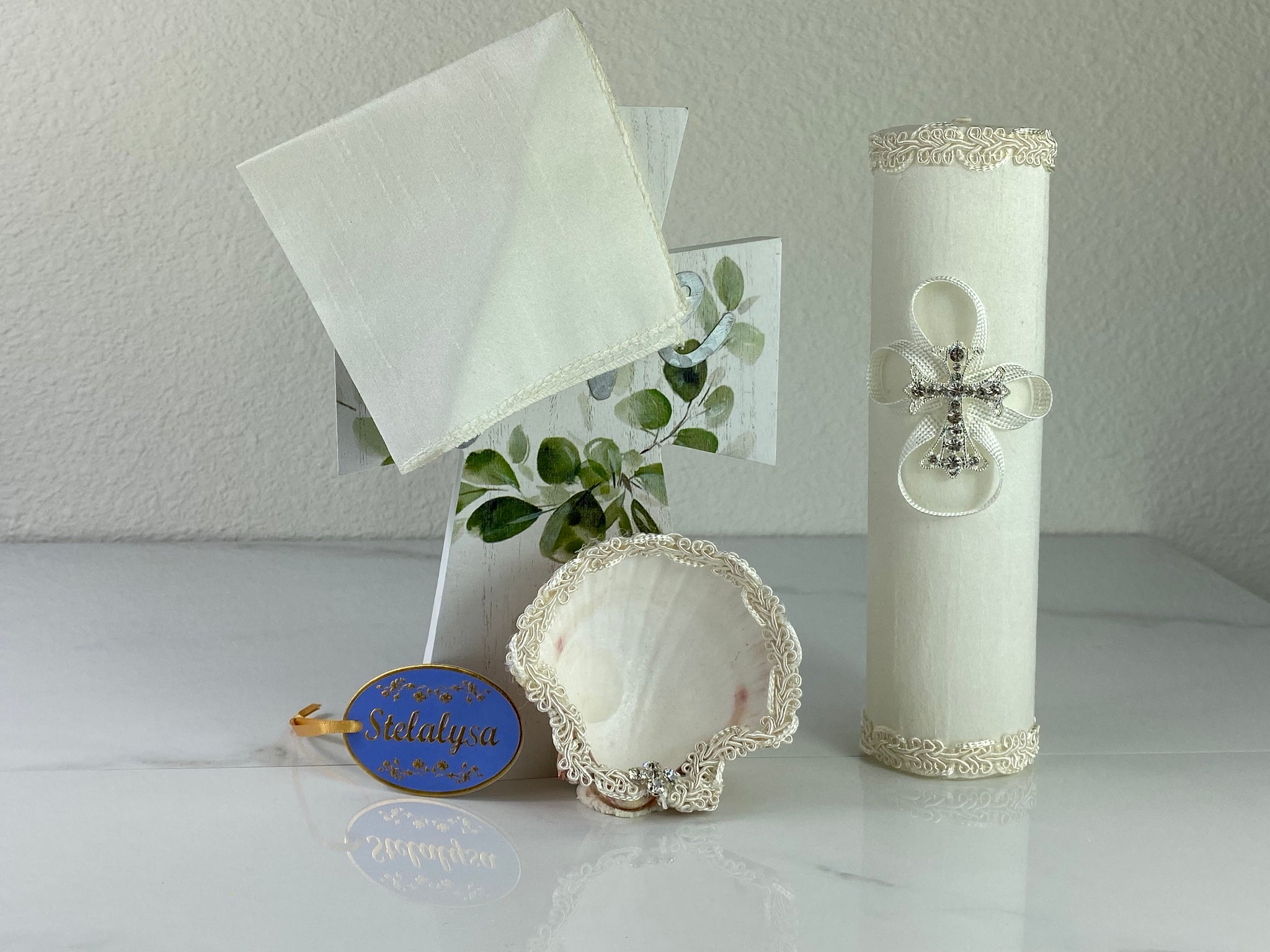 These one-of-a-kind Candle set is handmade and ivory in color.  This candle has a classic look.   It is uniquely decorated with lace and  cross made of crystals making it a gorgeous keepsake.   This candle is cylinder in shape and matches many outfits from the Boys' Baptism Collection.    To match, the Shell is put together piece by piece to compliment the Candle and Handkerchief.  The Handkerchief is made of satin to match the Shell and Candle beautifully.  