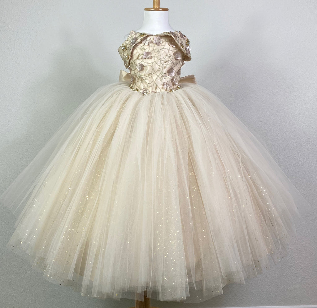 CHAMPAGNE   Off the shoulder with sweetheart neckline champagne bodice Gold embroidery with champagne flowers and rhinestones along tulle covering bodice and sleeves Large rhinestone band around lower bodice Champagne skirting with rose gold tulle and glittered gold tulle overlay Corset backing Large champagne bow on back Dress pictured with a petticoat Petticoat not included  Choose from a tulle, cloth, or wire for best look