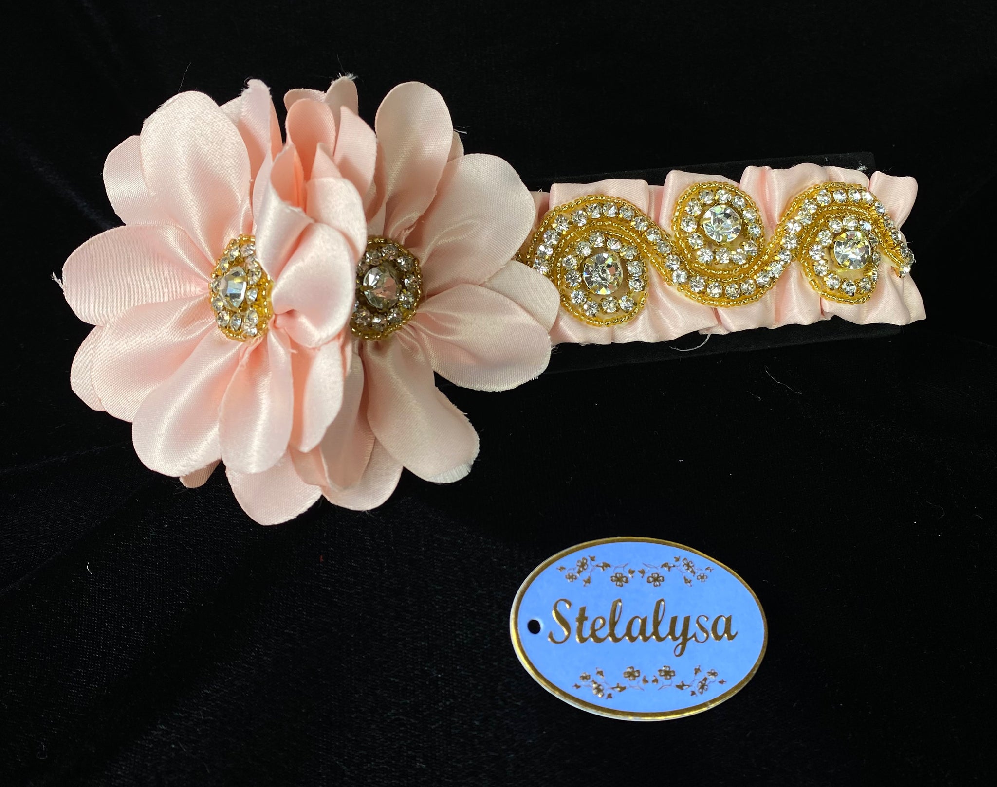 This is an elegant handmade and one-of-a-kind Pink headwrap with a two large satin flowers with gold beads and rhinestones.  The elastic headwrap is made of a soft satin with an intricate rhinestone and gold bead design.  This headwrap can be worn with dresses from Stelalysa's Celebration/Pageant Collection and for any occasion!  It fits best on ages 1-6.