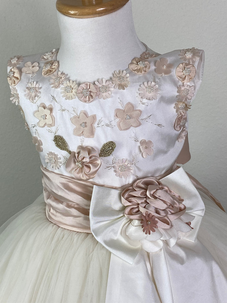 Bodice with rose gold pearled flower detailing along neckline and sleeves Flower detailing along bodice with brown embroidered petals Rose gold cummerbund with large ivory bow Rose gold flower in center of large ivory bow Embroidered flowers scattered among tulle skirting Rose gold flowers with pearl centers trimmed around skirting Satin button closure Rose gold ribbon for large bow on back Dress pictured with a petticoat Petticoat not included  Choose from a tulle, cloth, or wire for best look