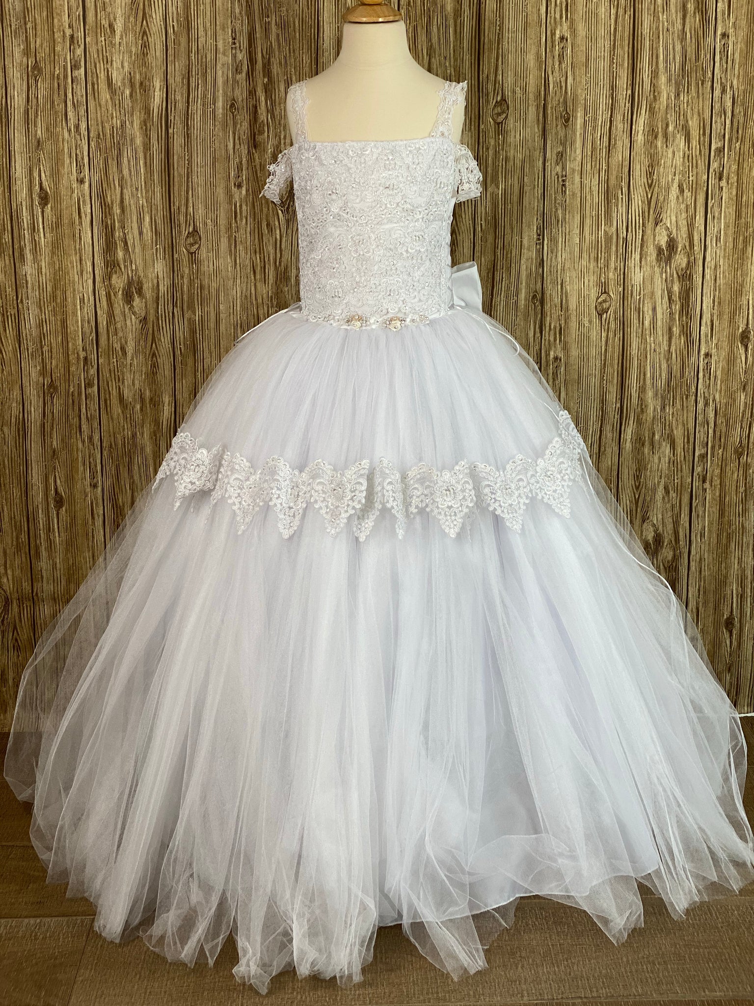 White, size 12 Squared neck Lace embroidered bodice Pearl, rhinestone, and rose thin band along bottom of bodice Layered tulle skirt with embroidered trim on top layer Button closure Big satin bow on back