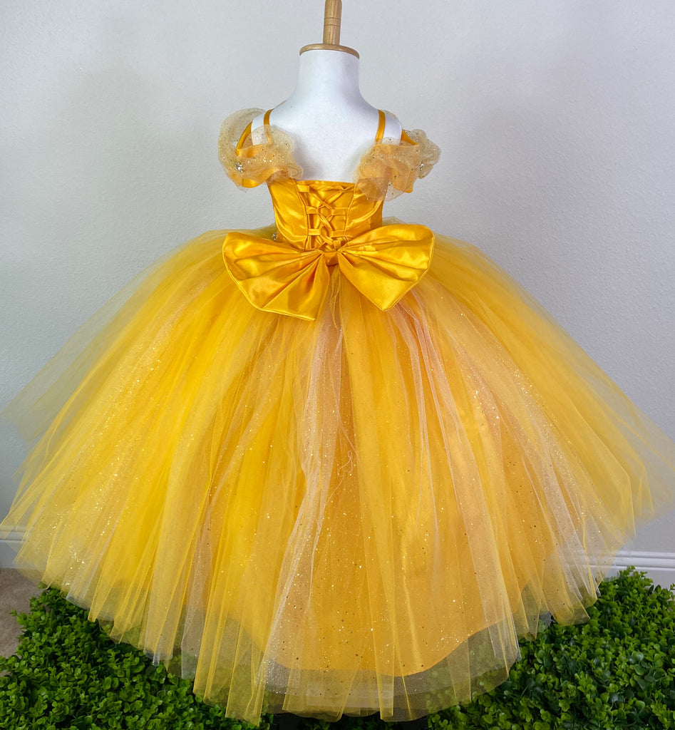 This beautiful dress comes in two colors- Yellow & Blue Satin bodice  Off the shoulder sleeve Sparkle tulle wrapping around bodice and sleeves Rhinestones placed throughout tulle Swirled rhinestone belting Large tulle skirting with peak-a-boo sparkle tulle Coreset style back Large bow on back Dress pictured with a petticoat Petticoat not included  Choose from a tulle, cloth, or wire for best look
