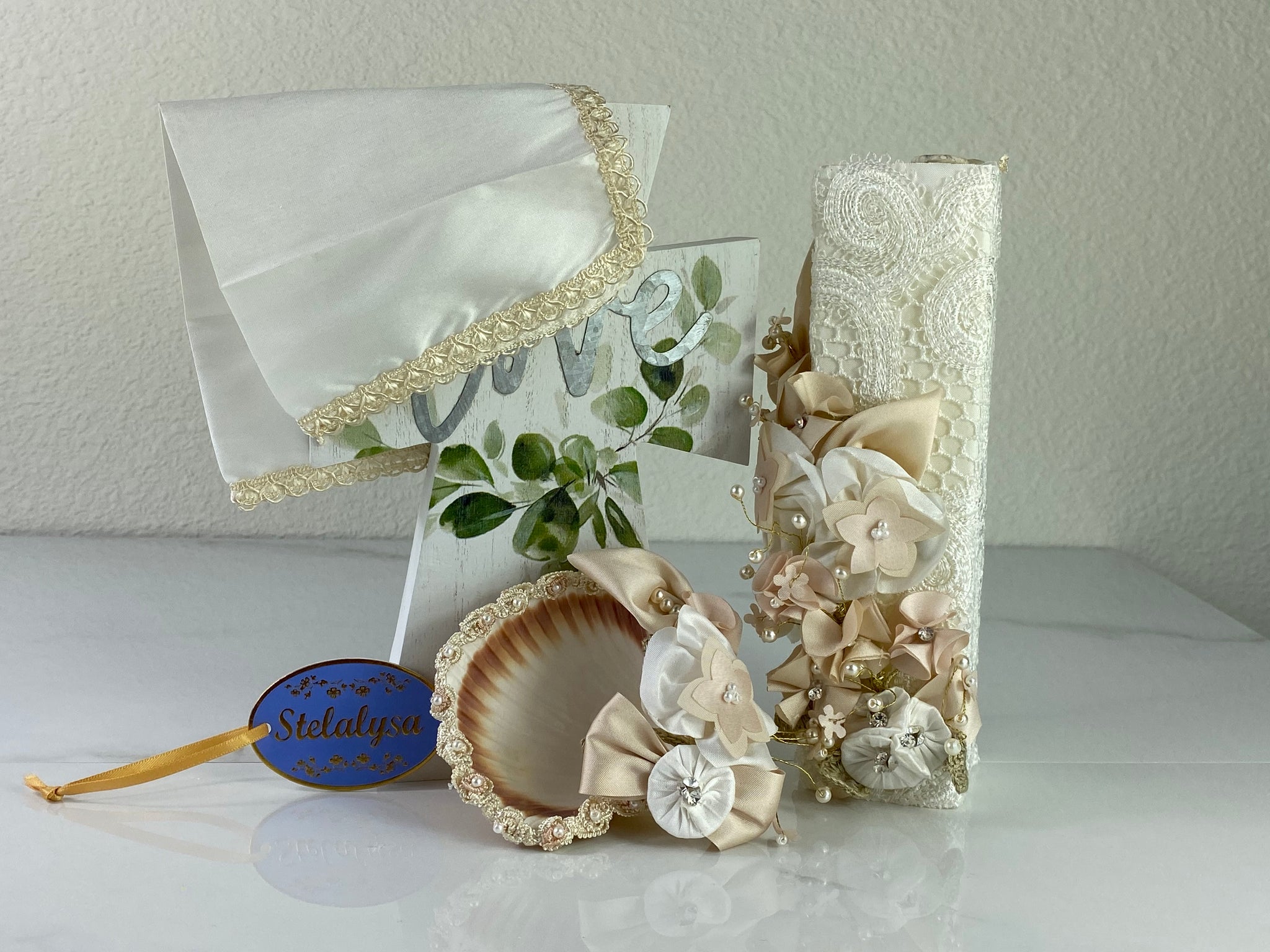 These one-of-a-kind Candle set is handmade and ivory in color.  This candle can also be use with a white baptism outfit because it has an array of light colors including white.   It is uniquely decorated with ribbon, pearls, crystals, flowers, and beads making it a gorgeous keepsake.   This candle is rectangular in shape.    To match, the Shell is put together piece by piece to compliment the Candle and Handkerchief.  