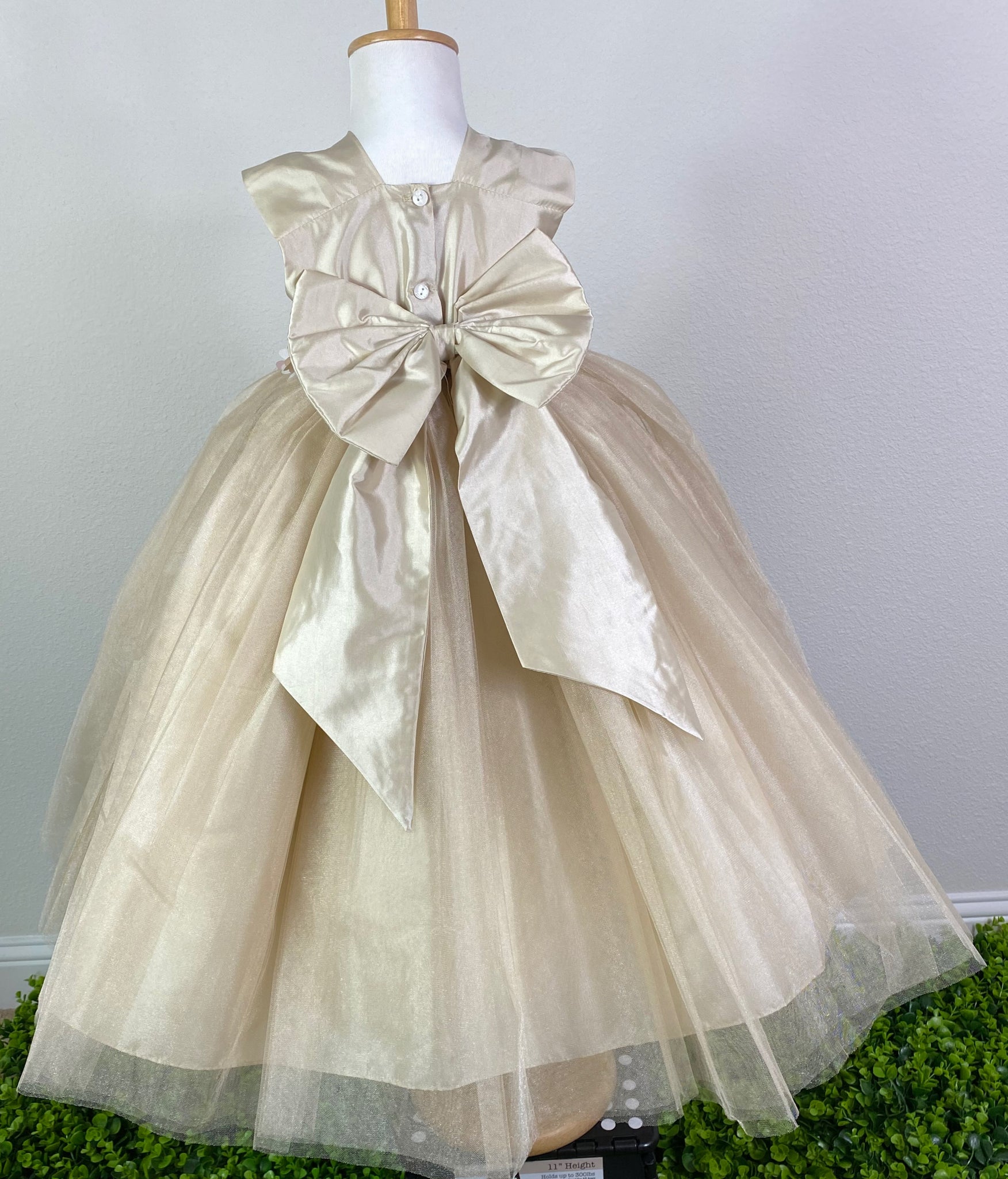  CHAMPAGNE  Champagne squared neck bodice Rose gold, ivory and brown flower with pearl center cummerbund Champagne ruched tulle and satin skirting Button closure Large champagne bow on back Dress pictured with a petticoat Petticoat not included  Choose from a tulle, cloth, or wire for best look