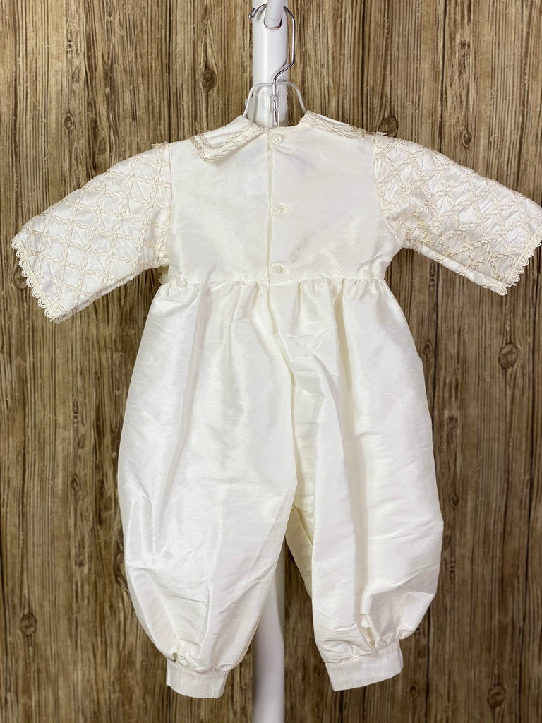 This a beautiful, one-of-a-kind boy’s baptism gown/set.  Lovely clothes for a precious child.  4-piece ivory set including romper, beret, one piece stole, and detachable skirting Diagonal overlapping trim with pearl beading on stole, skirting, and romper Wide embroidered ribbon down skirting Button closure on skirting, inside pant legs, and back of romper Braided layered trim along collar Half sleeve Embroidered scalloped trim around stole and sleeve edge