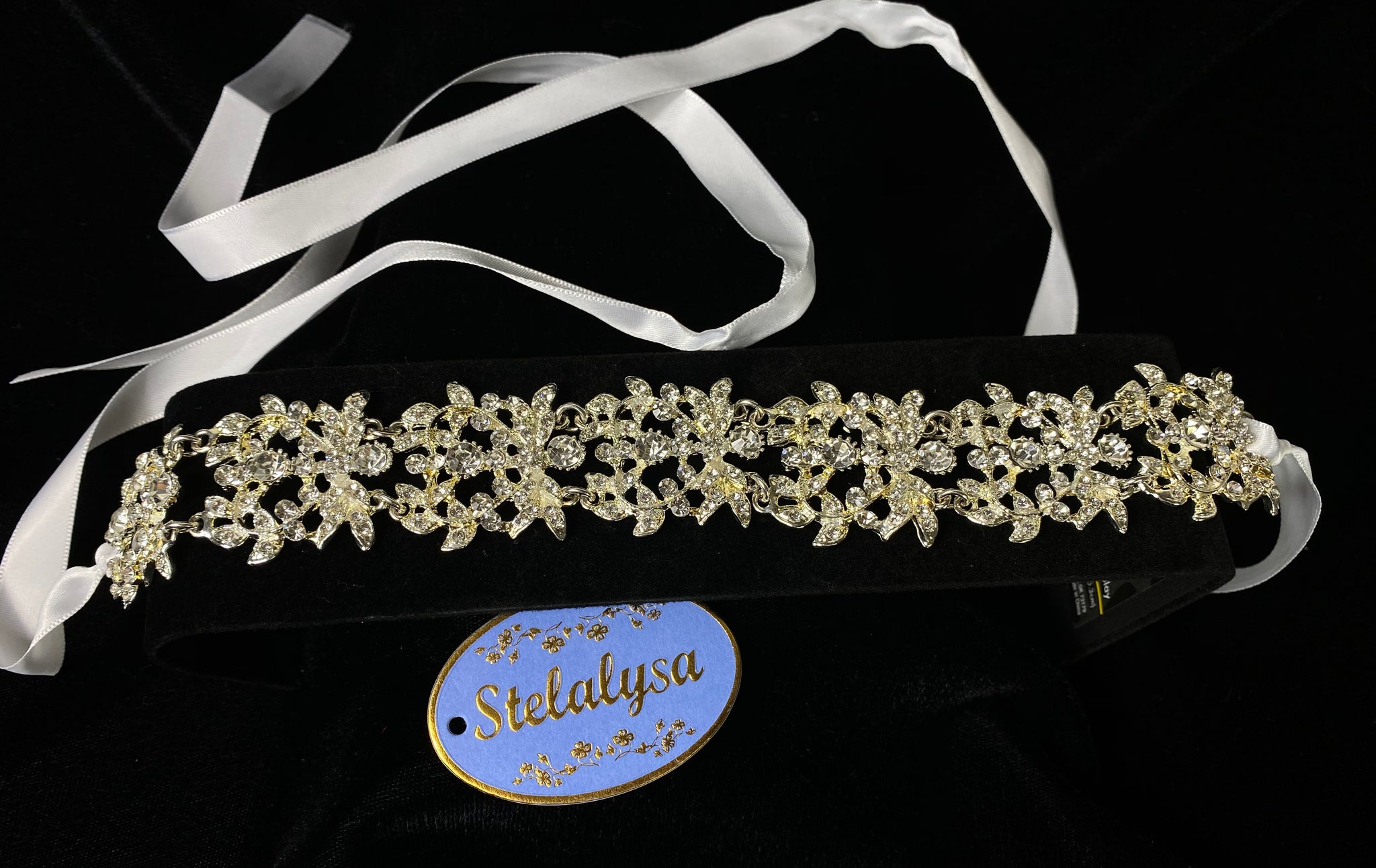 Communion Tie Back Headband   This is an elegant one-of-a-kind rhinestone headband.  Rhinestones are placed on metal with a smooth finish on back.  The headband ties with two satin ribbons giving it an elegant look.   This headband can be worn with any of the First Communion dresses.  Great look for after the ceremony.  She will look like the princess she is with this headband on her special day!  