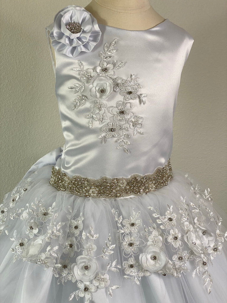 White, size 10 Satin bodice with flower on shoulder and embroidered lace detailing Pearl and rhinestone belt Layered tulle skirt with embroidered flowers with rhinestones on top layer Corset closure Satin ribbon for belt