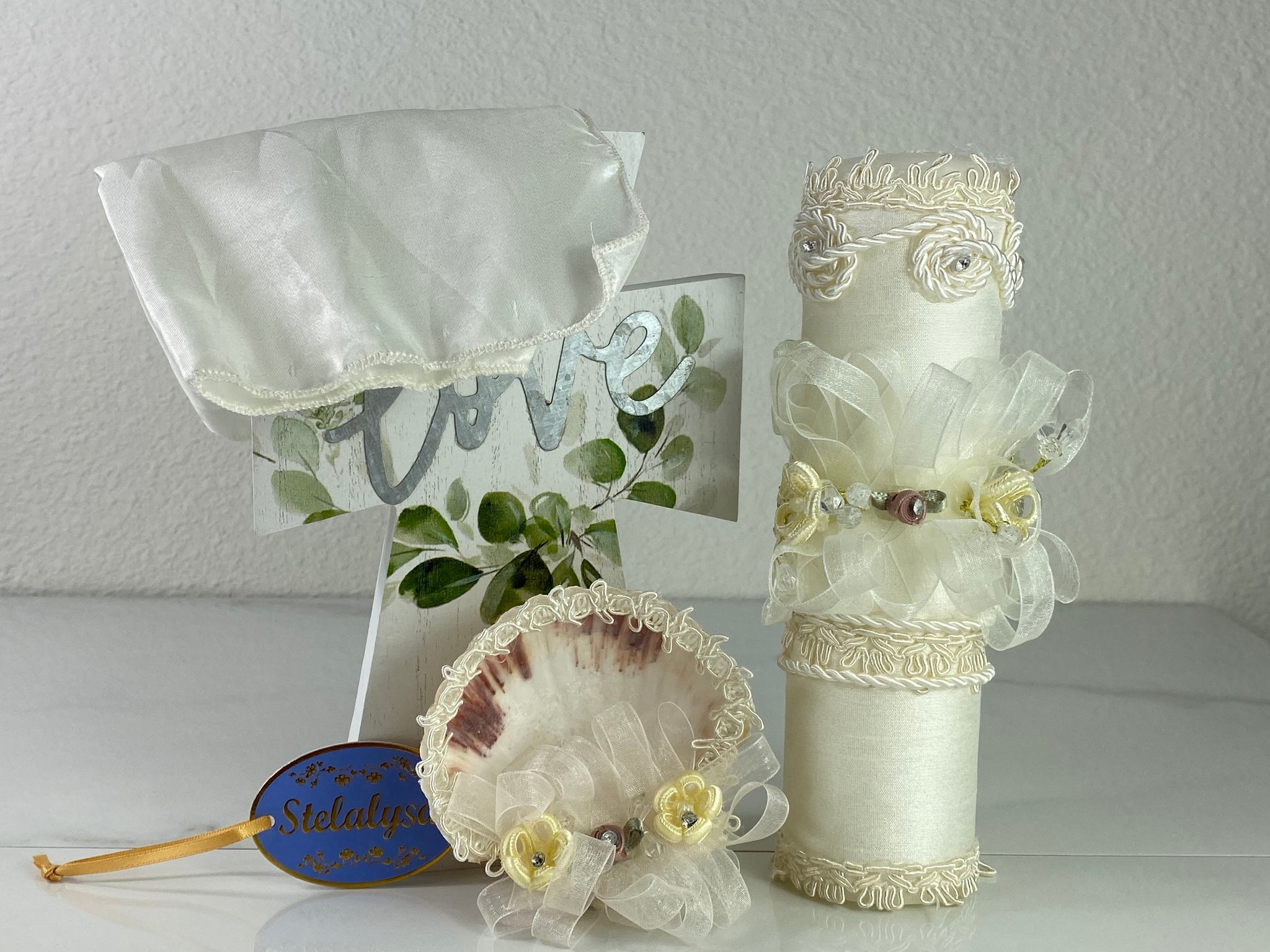 These one-of-a-kind Candle set is handmade and ivory in color.  This candle has a classic look.   It is uniquely decorated with crystals, lace, cross, and tassels making it a gorgeous keepsake.   This candle is cylinder in shape and matches many outfits from the Boys' Baptism Collection.    To match, the Shell is put together piece by piece to compliment the Candle and Handkerchief.  The Handkerchief is made of satin to match the Shell and Candle beautifully.  