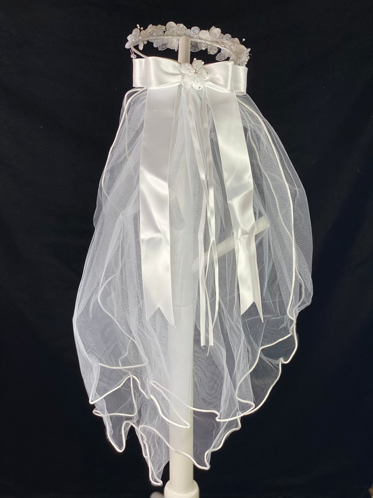 Elegant soft 2 layer tulle veil with delicate hand stitched braided satin trim around the edge and handmade flower halo crown with veil with large white satin bow on back. Stain flowers with sparkling rhinestone petals and centers. Crystal flowers between organza flowers. Beautiful lace leaves sticking out around flowers.  This double layered veil reaches approximately 24" long, with a crown diameter of 6". Veil has 2" long, 3" wide, comb to secure it in place. 