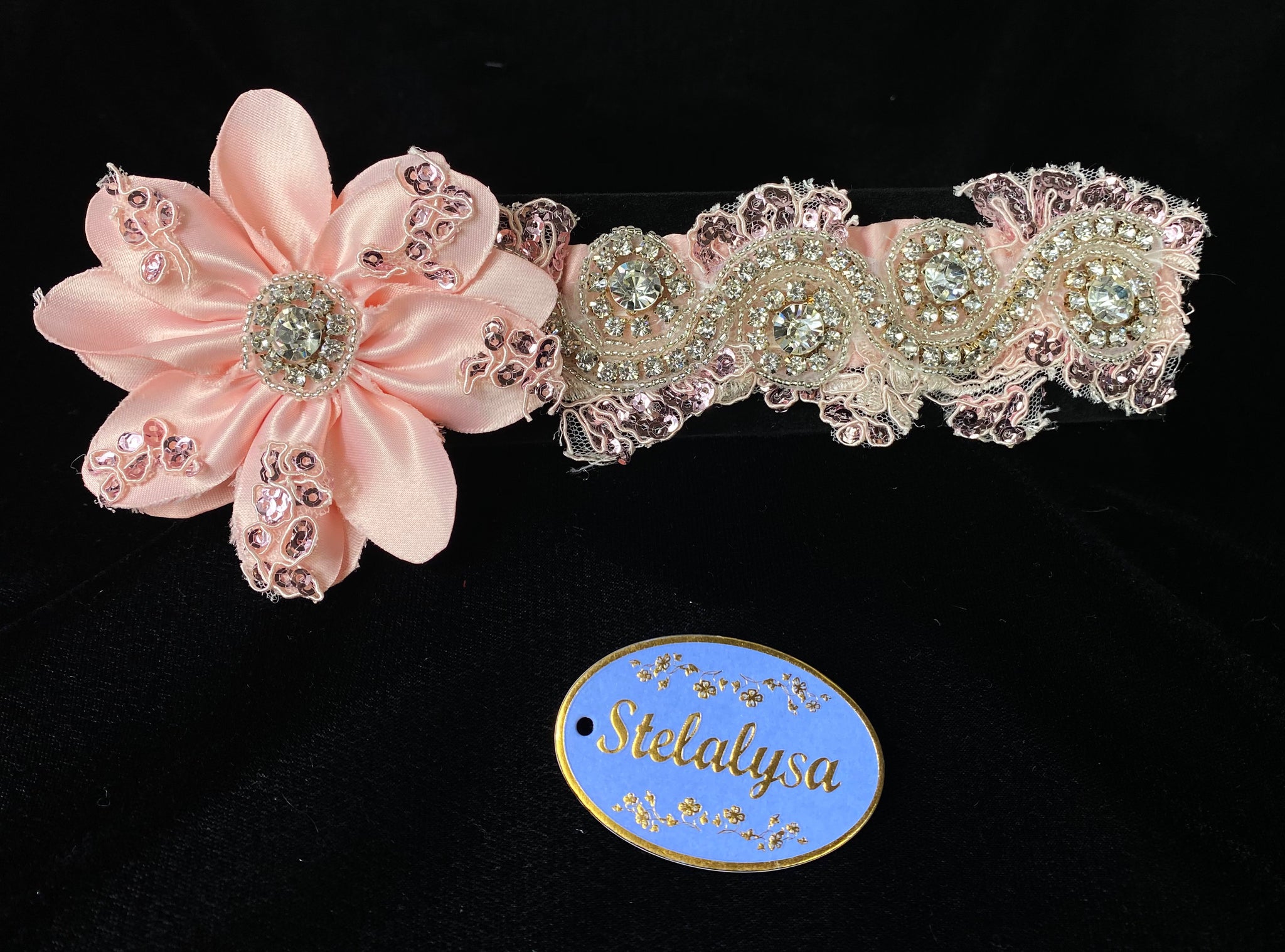 This is an elegant handmade and one-of-a-kind Pink headwrap with a large satin flower with sequins and rhinestones.  The headwrap is made of a soft satin elastic with an intricate rhinestone design.  This headwrap can be worn with dresses from Stelalysa's Celebration/Pageant Collection and for any occasion!  It fits best on ages 1-6.