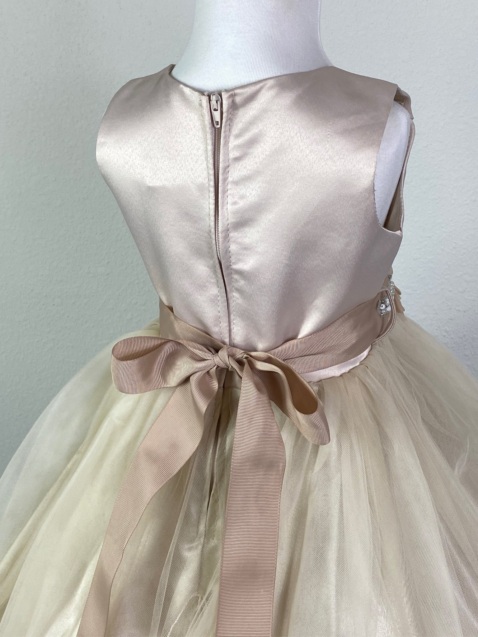 Champagne, size 2 Champagne paneled bodice Beige ribbon belt with rhinestone and bead detailing along leaves Champagne satin skirting with tulle overlay Zipper closure Dress pictured with a petticoat Petticoat not included  Choose from a tulle, cloth, or wire for best look