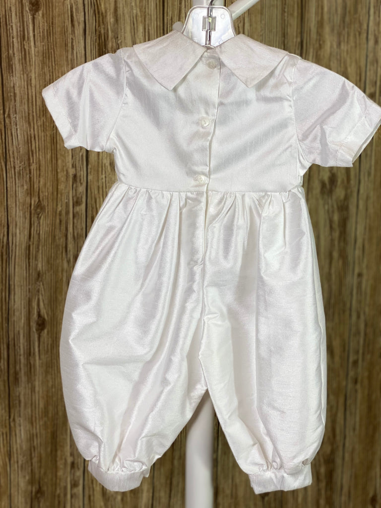 WHITE  3-piece white set with romper, jacket, and bonnet Solid white satin romper with buttons along inside of legs Collard, short sleeve romper Silver rope detailing in L shape on jacket front Silver rope detailing vertical along jacket collar and sleeves Embroidered appliques on jacket front Embroidered trim along jacket, collar, and sleeve edging Ribbon closure on jacket Button closure on back of romper Thin ribbon for tie on bonnet