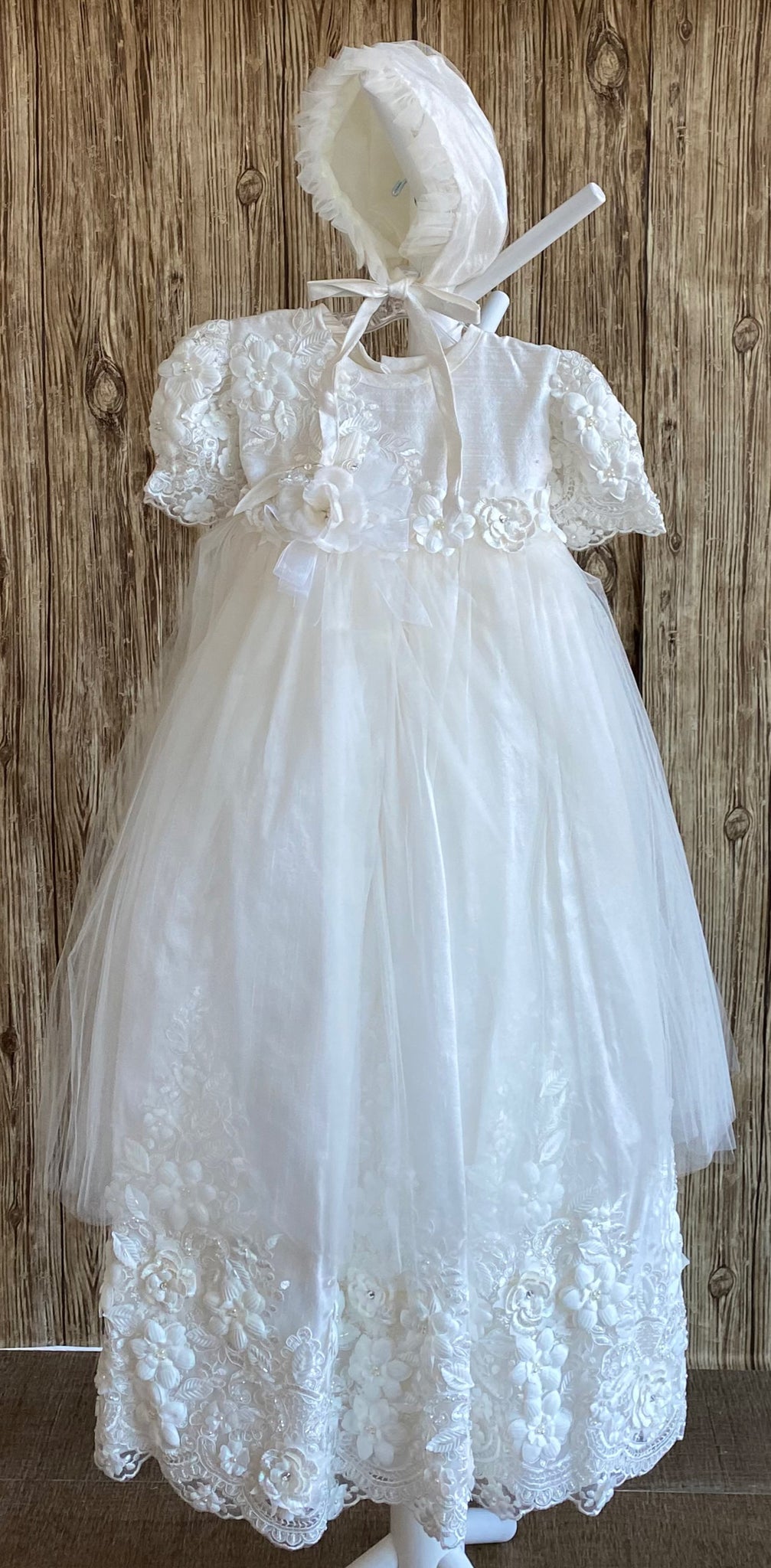 This a beautiful, one-of-a-kind baptism gown.  A lovely gown for a precious child.  Ivory, size 12M Satin bodice with large floral embroidered detailing Floral embroidered sleeves Intricate flowered belting along bodice  Tulle skirting over floral embroidery Rhinestone centers on embroidered flowers Satin bonnet with large embroidered flower Pearl center on bonnet flower Ruffled tulle around brim of bonnet Satin ribbon closure on bonnet
