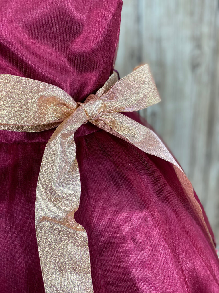 Burgundy satin bodice with tulle overlay Gold ribbon for bow in front or back Embroidered gold applique along edge of skirting Zipper closure Dress pictured with a petticoat Petticoat not included  Choose from a tulle, cloth, or wire for best look