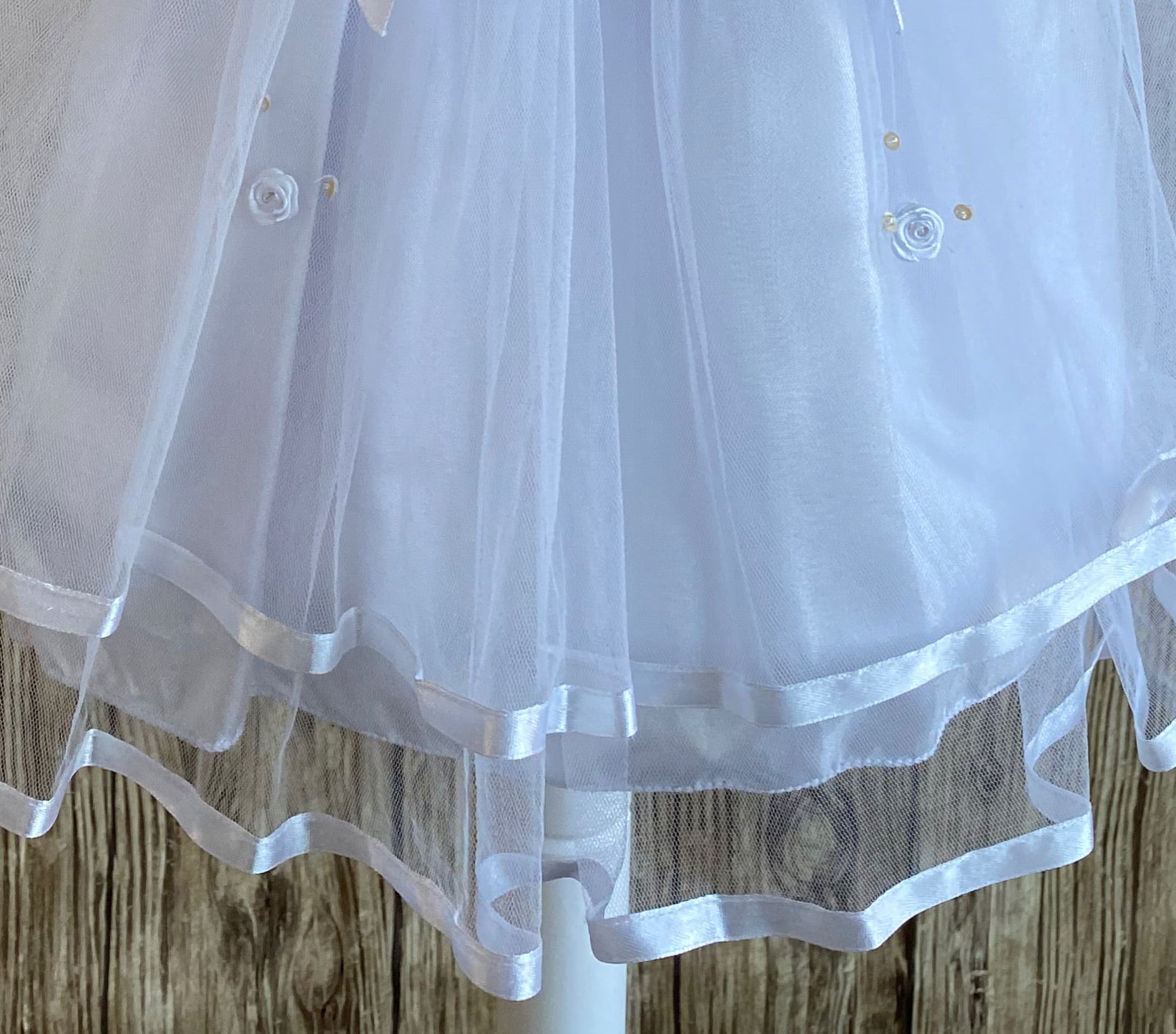 This a beautiful, one-of-a-kind baptism gown.  A lovely gown for a precious child.  White, size 12M Satin bodice with gold (sequins) and white embroidered flowers White cap sleeve  Large bow with floral center on bodice edge Tulle skirting with white roses Ribbon edge around tulle skirt Large ribbon bow in back 