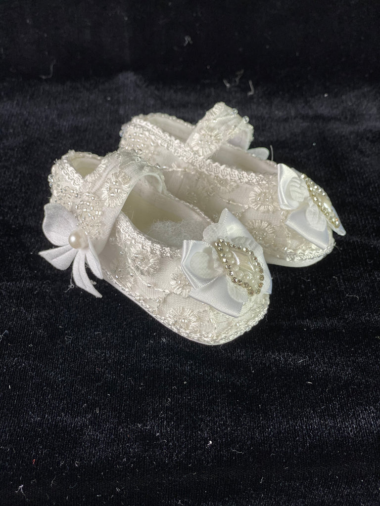 Elegant handmade ivory baby girl shoes with embroidery, lace, bows, and jewels.
