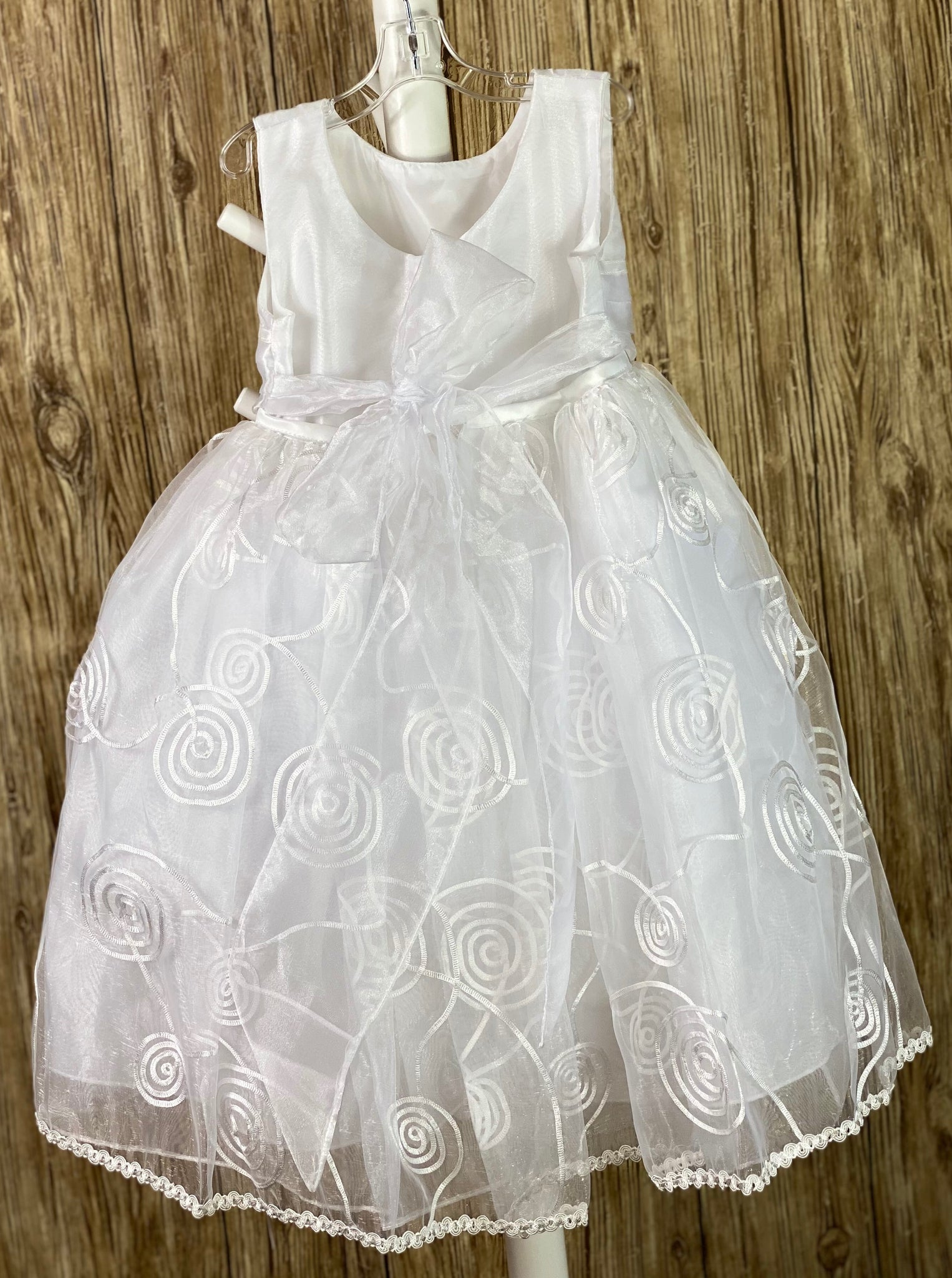 This a beautiful, one-of-a-kind baptism gown.  A lovely gown for a precious child.  White, size 24M Satin bodice Pleated satin belting Swirled mesh tulle skirting Mesh bow in the back