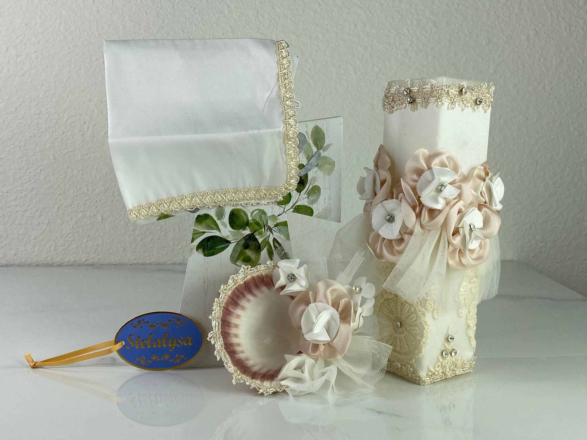 These one of a kind Candle set is handmade and ivory in color.   It is uniquely decorated with pears, crystals, ribbons, bows beads, and stunning embroidered lace making it a gorgeous keepsake.   This candle is rectangular in shape.    To match, the Shell is put together piece by piece to compliment the Candle and Handkerchief.  The Handkerchief is made of satin and embroidered lace to match the Shell and Candle beautifully.  