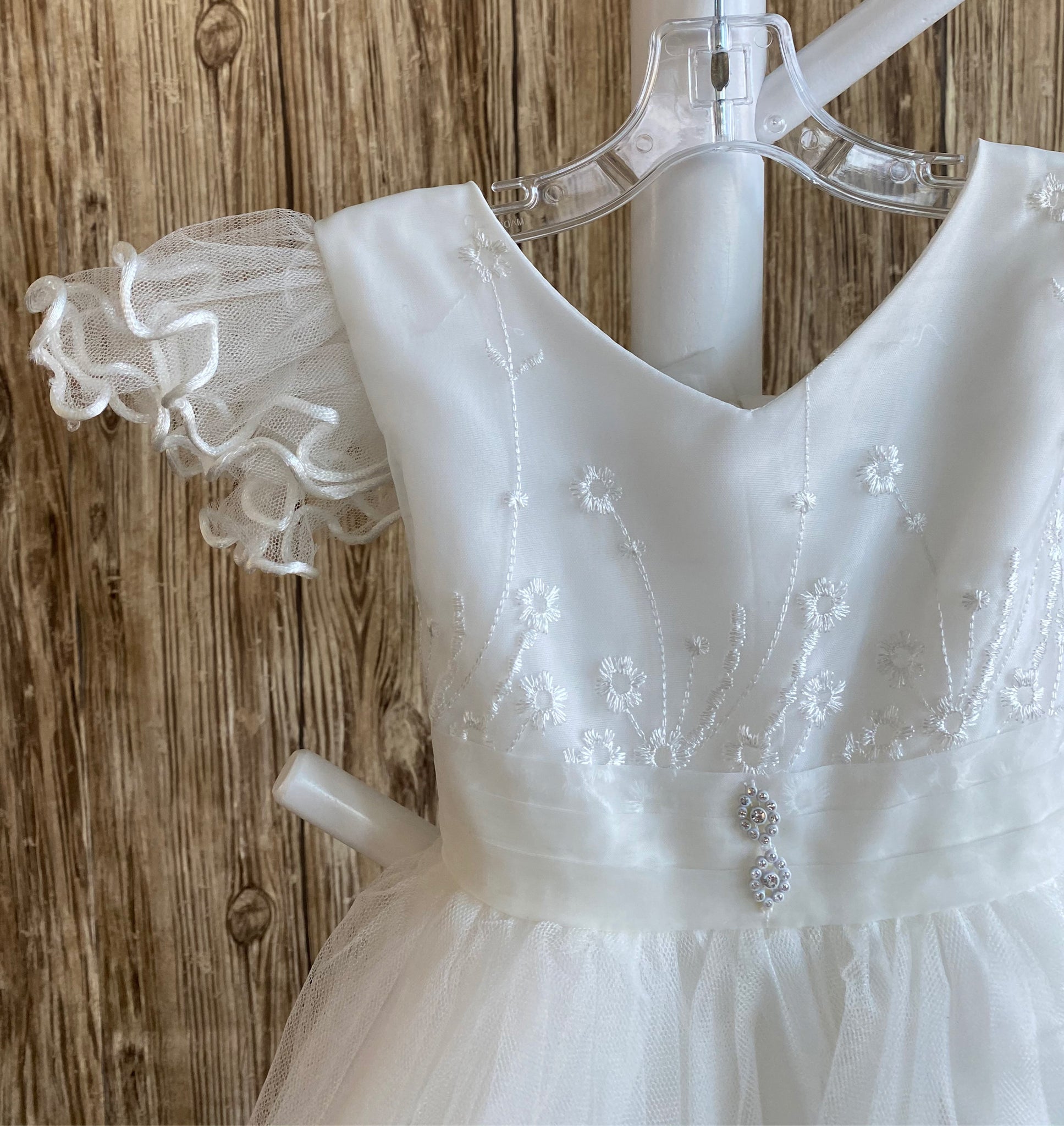 This a beautiful, one-of-a-kind baptism gown.  A lovely gown for a precious child.  White, size 12M Lettuce edge tulle sleeves Satin V-neck bodice with embroidered flowers 2 rhinestone flowers placed on middle of bodice edge Lace skirting with lettuce edge Roses placed throughout skirting 