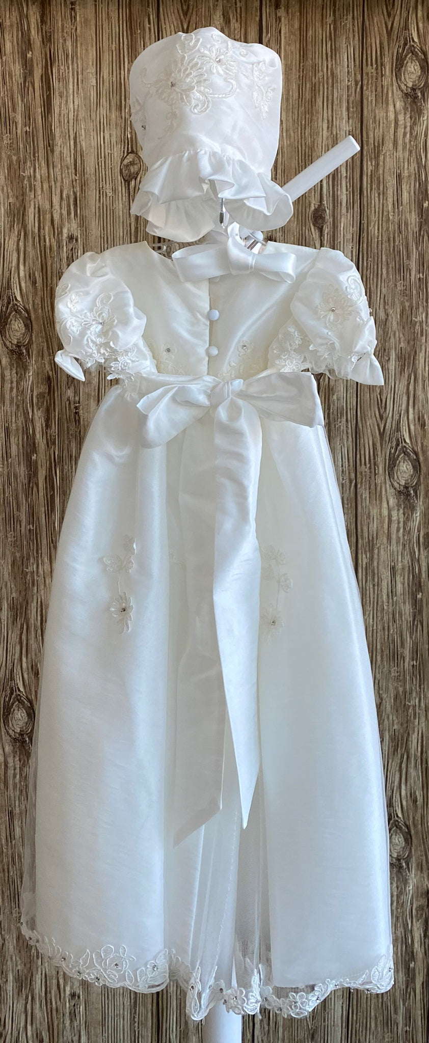 This a beautiful, one-of-a-kind baptism gown.  A lovely gown for a precious child.  Ivory, size 12M Satin bodice with embroidered floral overlay and rhinestone centers  Satin puff sleeve with embordered floral overlay tulle along arm hole Bow on both sleeves Gathered skirting around bodice Embroidered floral tulle overlay around skirting Beautiful flowered edge on skirt overlay Satin bonnet with embroidered flowers Gathered satin brim along bonnet Satin ribbon closure on bonnet