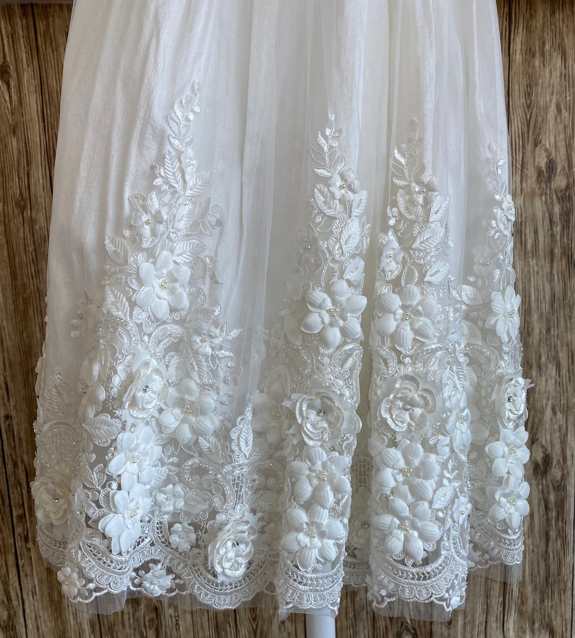This a beautiful, one-of-a-kind baptism gown.  A lovely gown for a precious child.  Ivory, size 6M  Satin bodice  Satin puffed sleeve Large pearl and rhinestone belt Tulle skirting with embroidered flowers along bottom Rhinestone centers on flowers