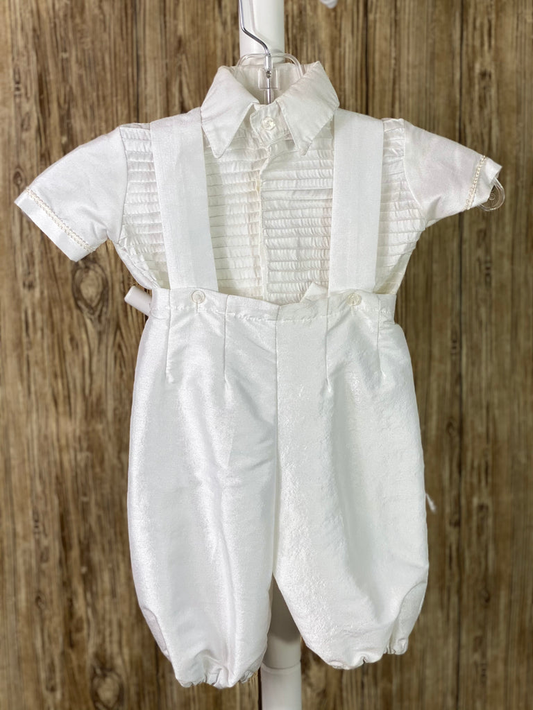 White, size 6M  4-piece set including shirt, pants, cape, beret Collared shirt with short sleeves Pinstriped bodice and sleeves on shirt Pinstripe on cape and beret Braided rope closure on cape Wide embroidered lace on cap edging Simple satin pants Elastic pant cuffs Elastic banding behind pants Button closure on back of shirt