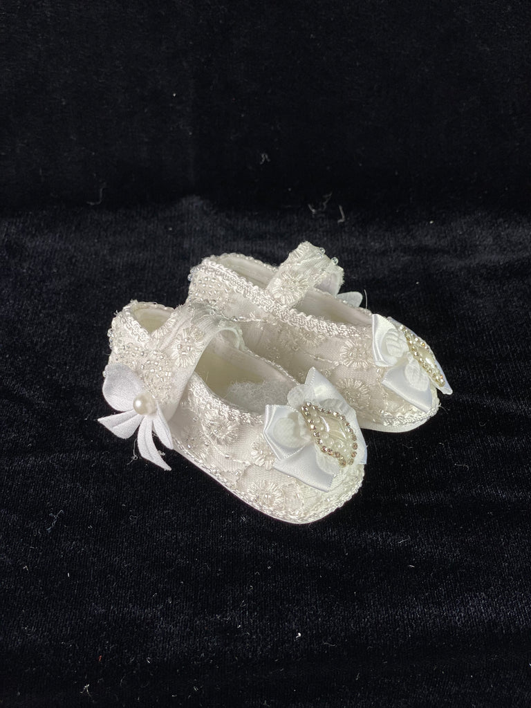 Elegant handmade ivory baby girl shoes with embroidery, lace, bows, and jewels.