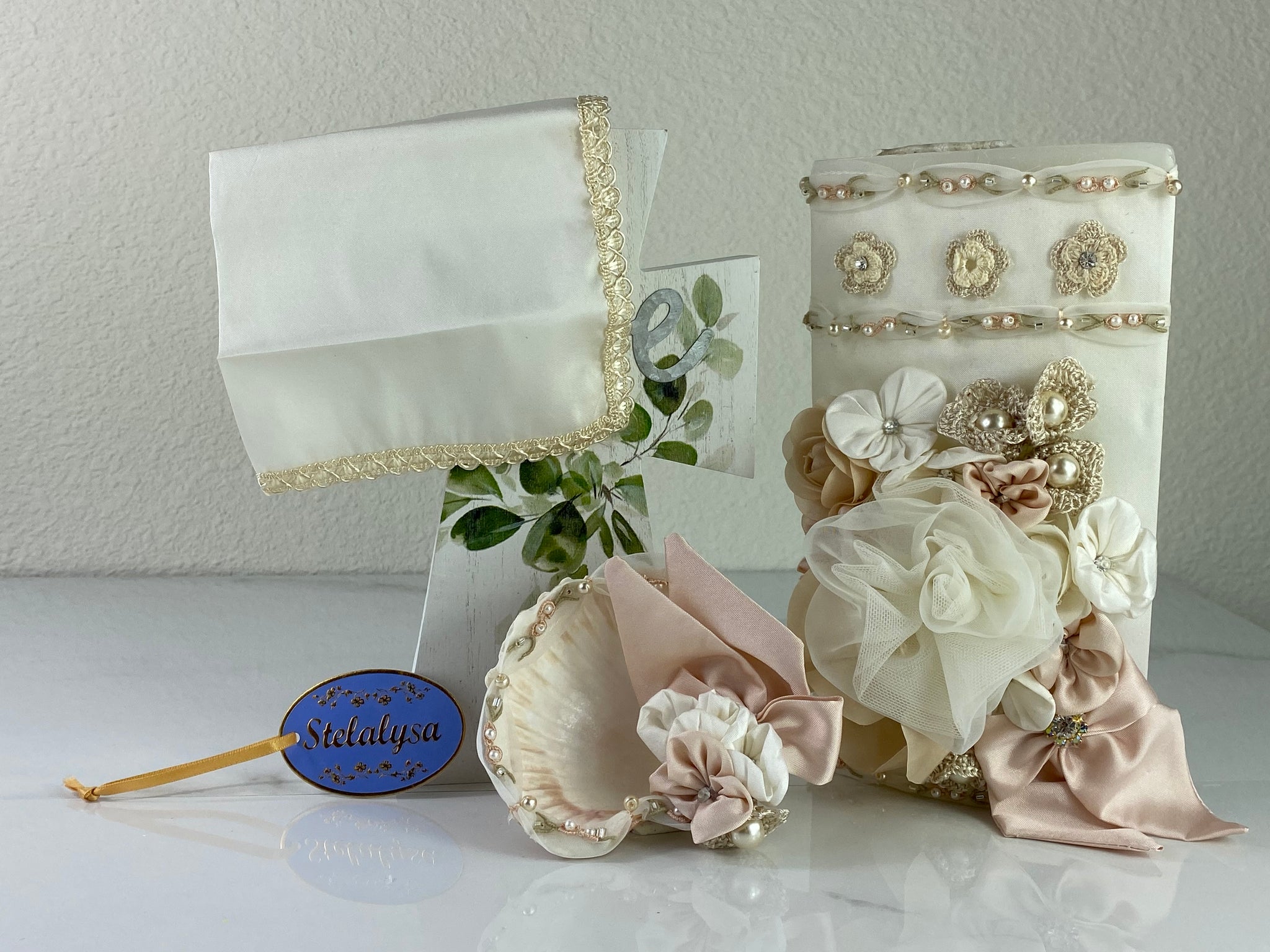 These one-of-a-kind Candle set is handmade and ivory in color.  This candle can also be use with a white baptism outfit because it has an array of light colors including white.   It is uniquely decorated with crochet and satin flowers, ribbon, pearls, crystals, and beads making it a gorgeous keepsake.   This candle is oval in shape.    To match, the Shell is put together piece by piece to compliment the Candle and Handkerchief. 