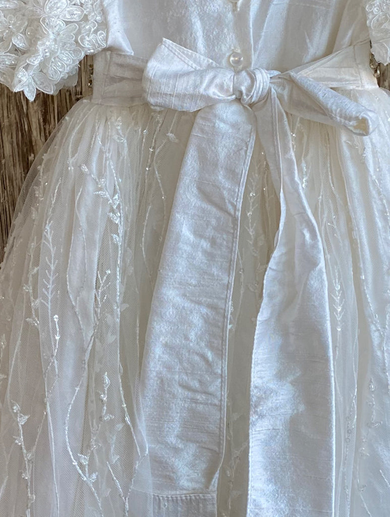 his a beautiful, one-of-a-kind baptism gown.  A lovely gown for a precious child.  White, size 6M  Textured satin bodice Knitted lace sleeves Intricate rhinestone belt Beaded tulle overlay on satin skirting 