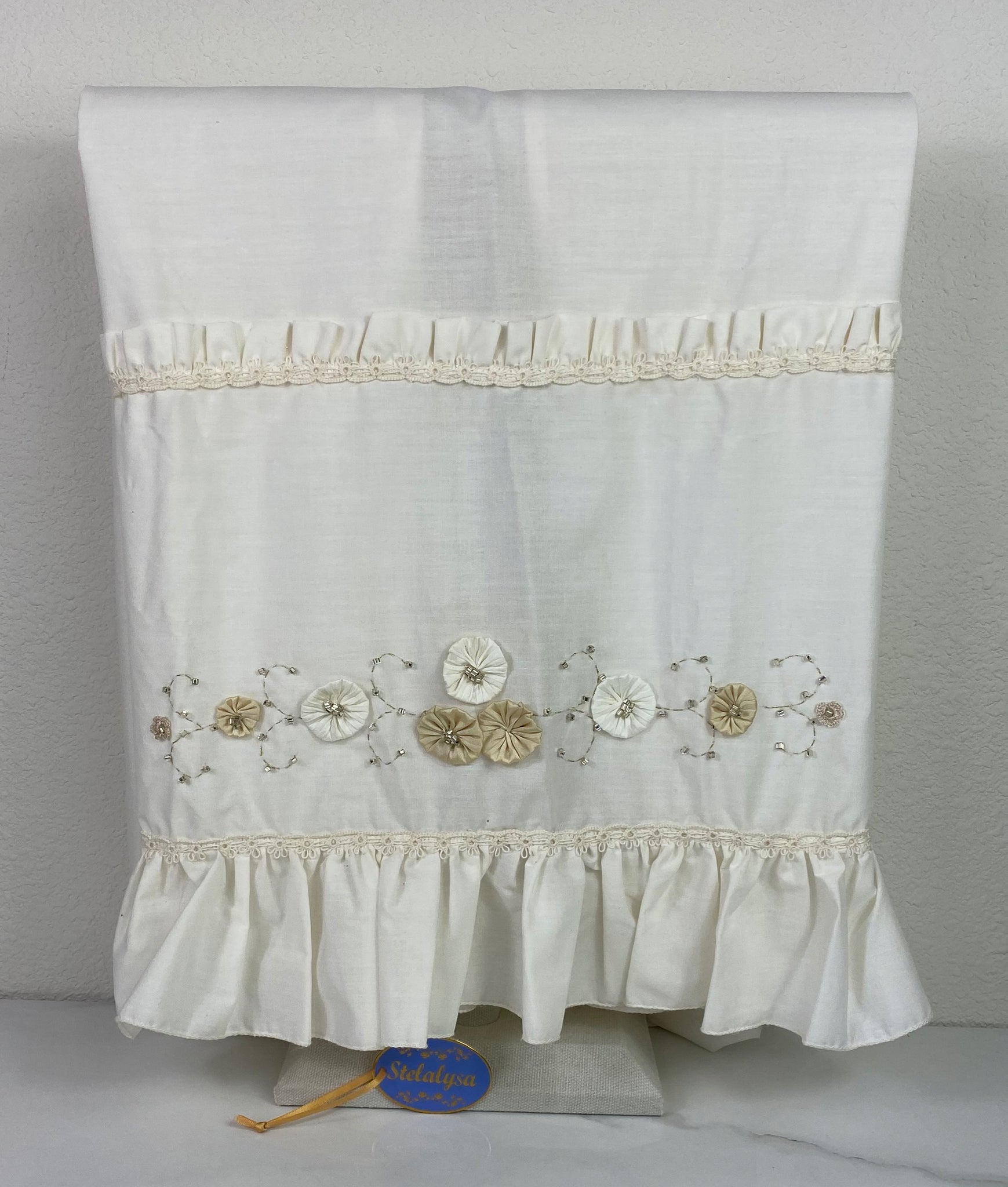 Beautiful ivory silk baptism blanket with flower, lace, and wide ruffled edge.