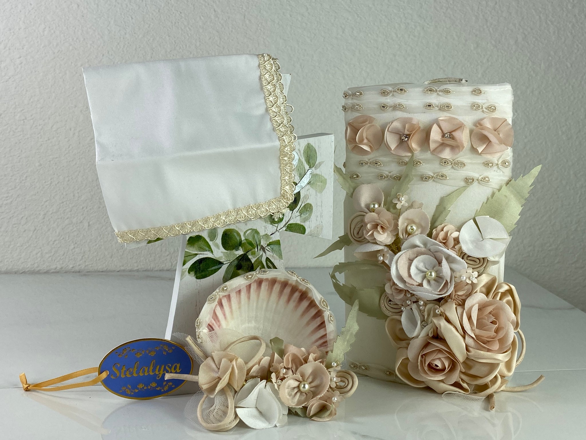 These one-of-a-kind Candle set is handmade and ivory in color.  This candle can also be use with a white baptism outfit because it has an array of light colors including white.   It is uniquely decorated with ribbon, pearls, crystals, flowers, and beads making it a gorgeous keepsake.   This candle is oval in shape.    To match, the Shell is put together piece by piece to compliment the Candle and Handkerchief.  