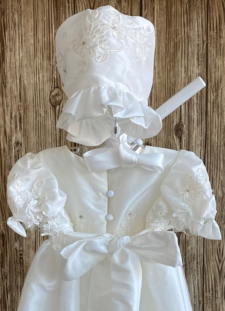 This a beautiful, one-of-a-kind baptism gown.  A lovely gown for a precious child.  Ivory, size 12M Satin bodice with embroidered floral overlay and rhinestone centers  Satin puff sleeve with embordered floral overlay tulle along arm hole Bow on both sleeves Gathered skirting around bodice Embroidered floral tulle overlay around skirting Beautiful flowered edge on skirt overlay Satin bonnet with embroidered flowers Gathered satin brim along bonnet Satin ribbon closure on bonnet