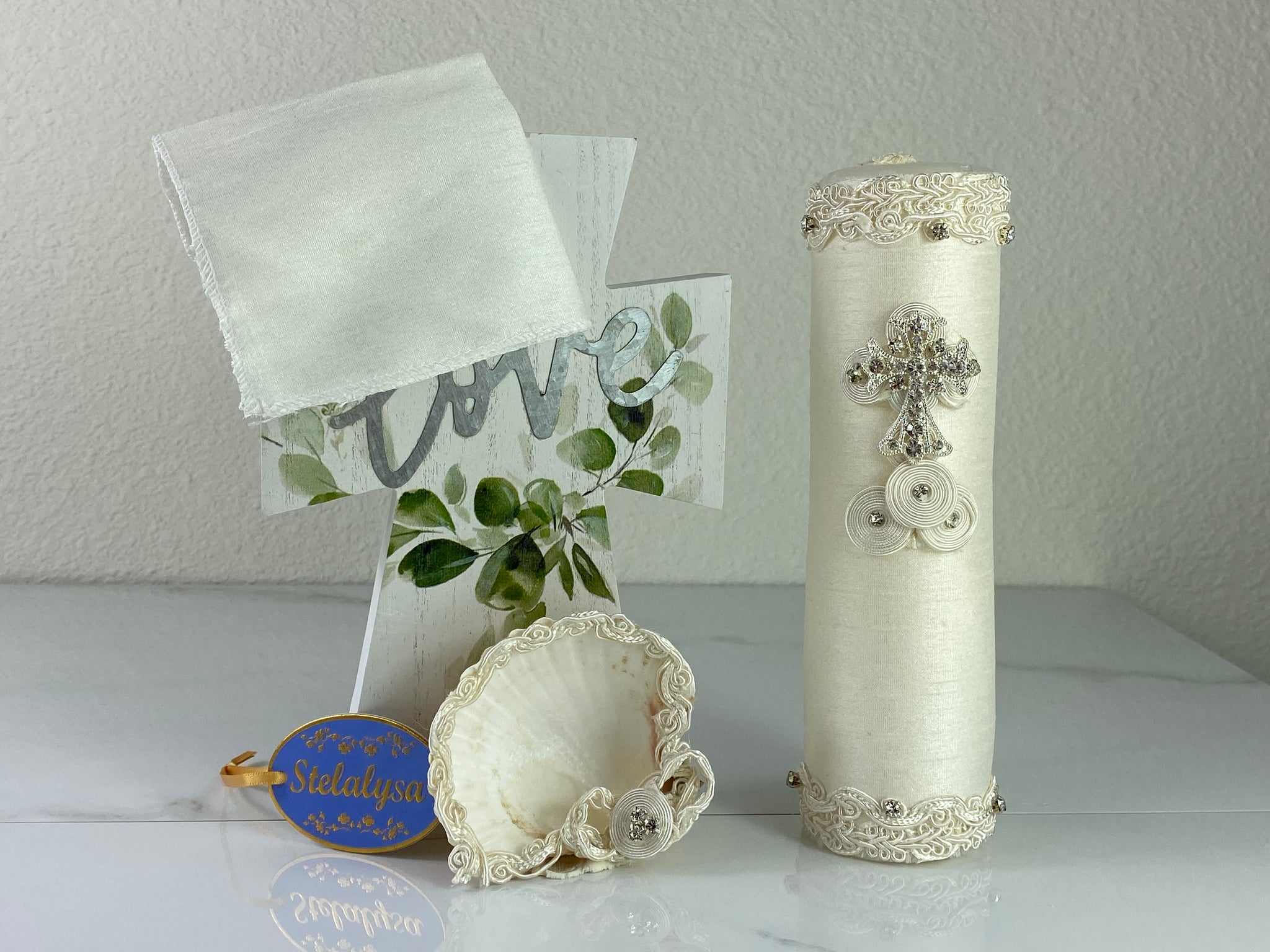 These one-of-a-kind Candle set is handmade and ivory in color.  This candle has a classic look.   It is uniquely decorated with crystals, lace, cross, and tassels making it a gorgeous keepsake.   This candle is cylinder in shape and matches many outfits from the Boys' Baptism Collection.    To match, the Shell is put together piece by piece to compliment the Candle and Handkerchief.  